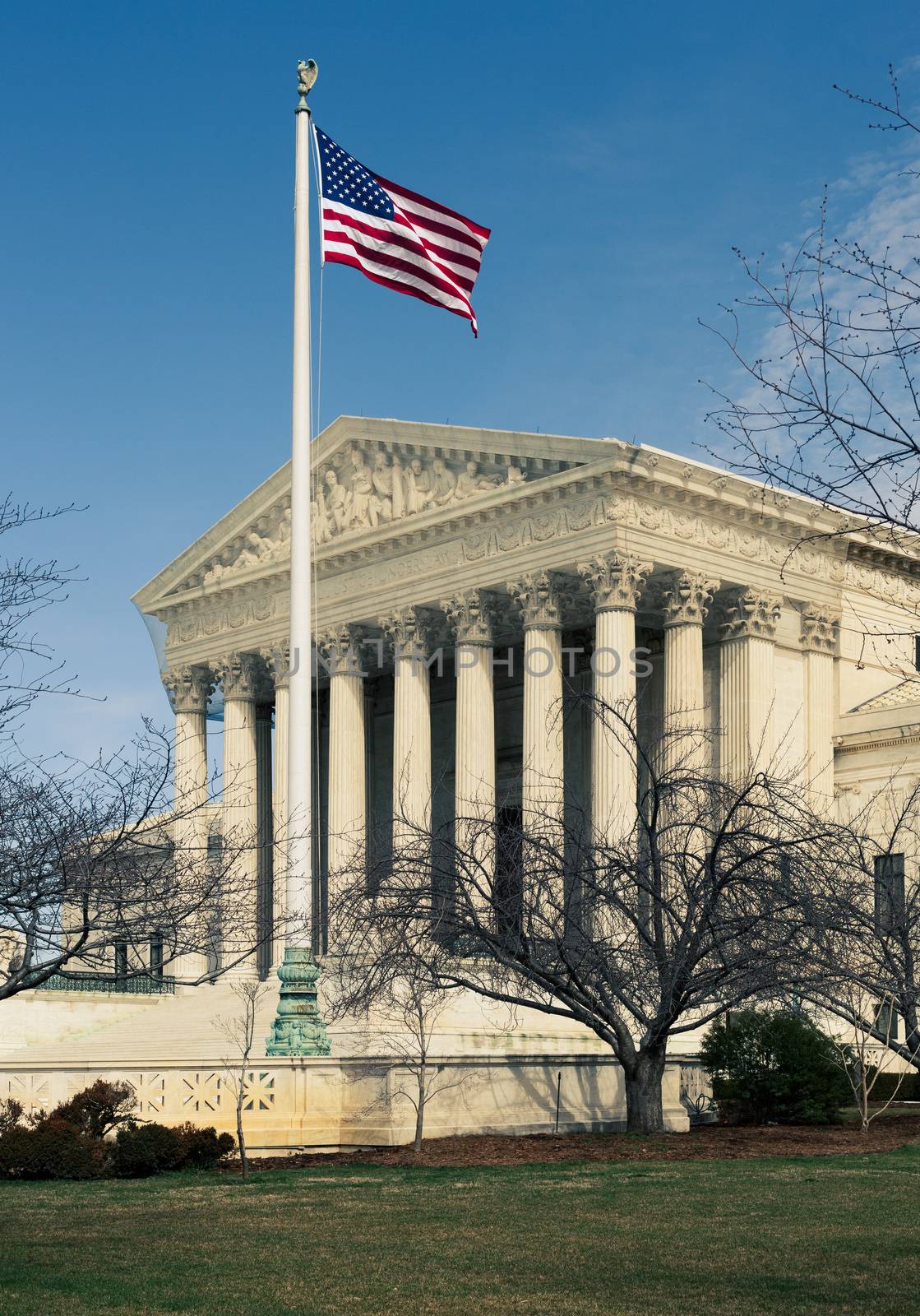 Supreme Court in Washington DC with the US flag flying in front of the building by steheap