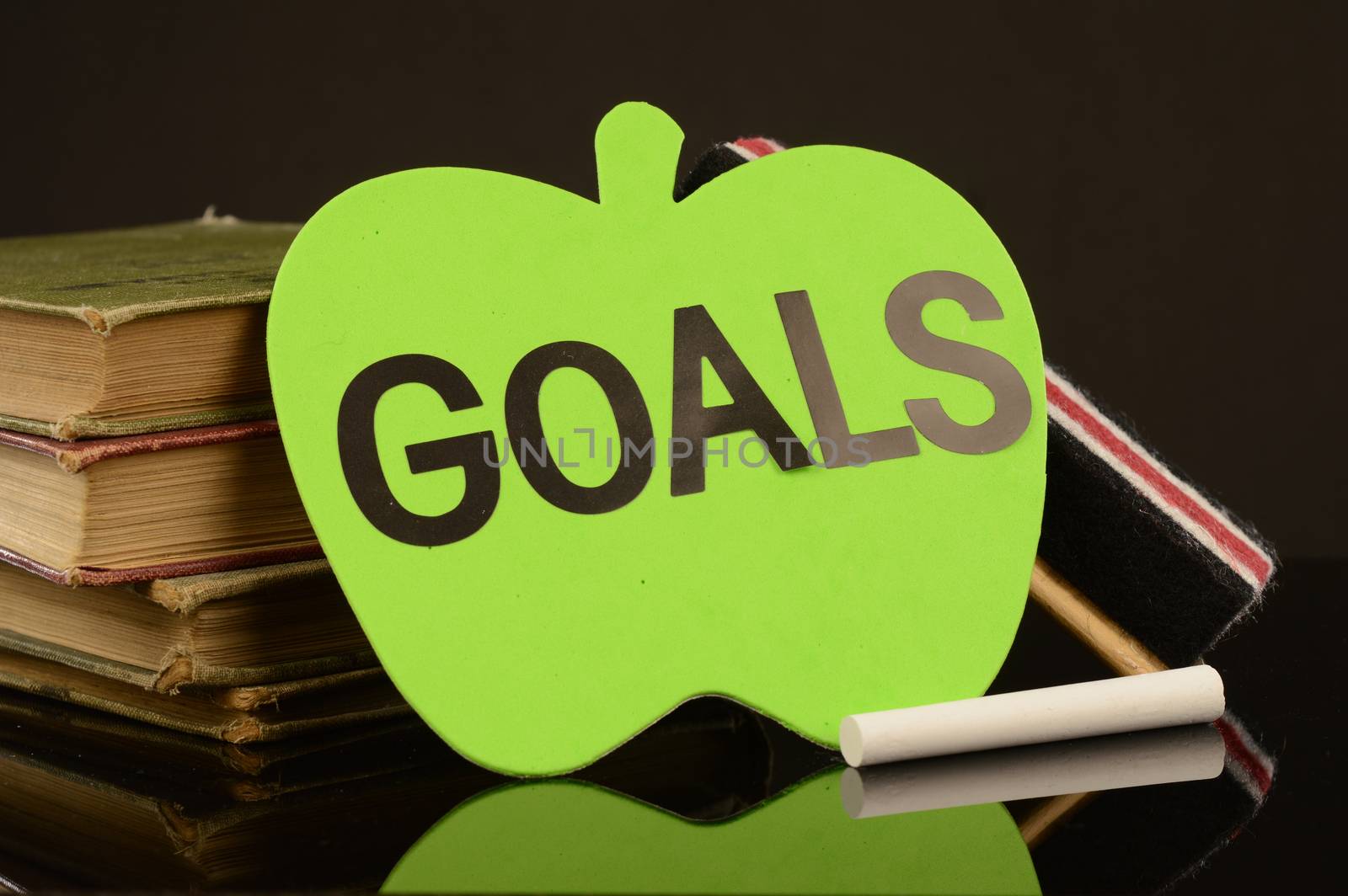 A green apple witht the word goals to implement daily routine.