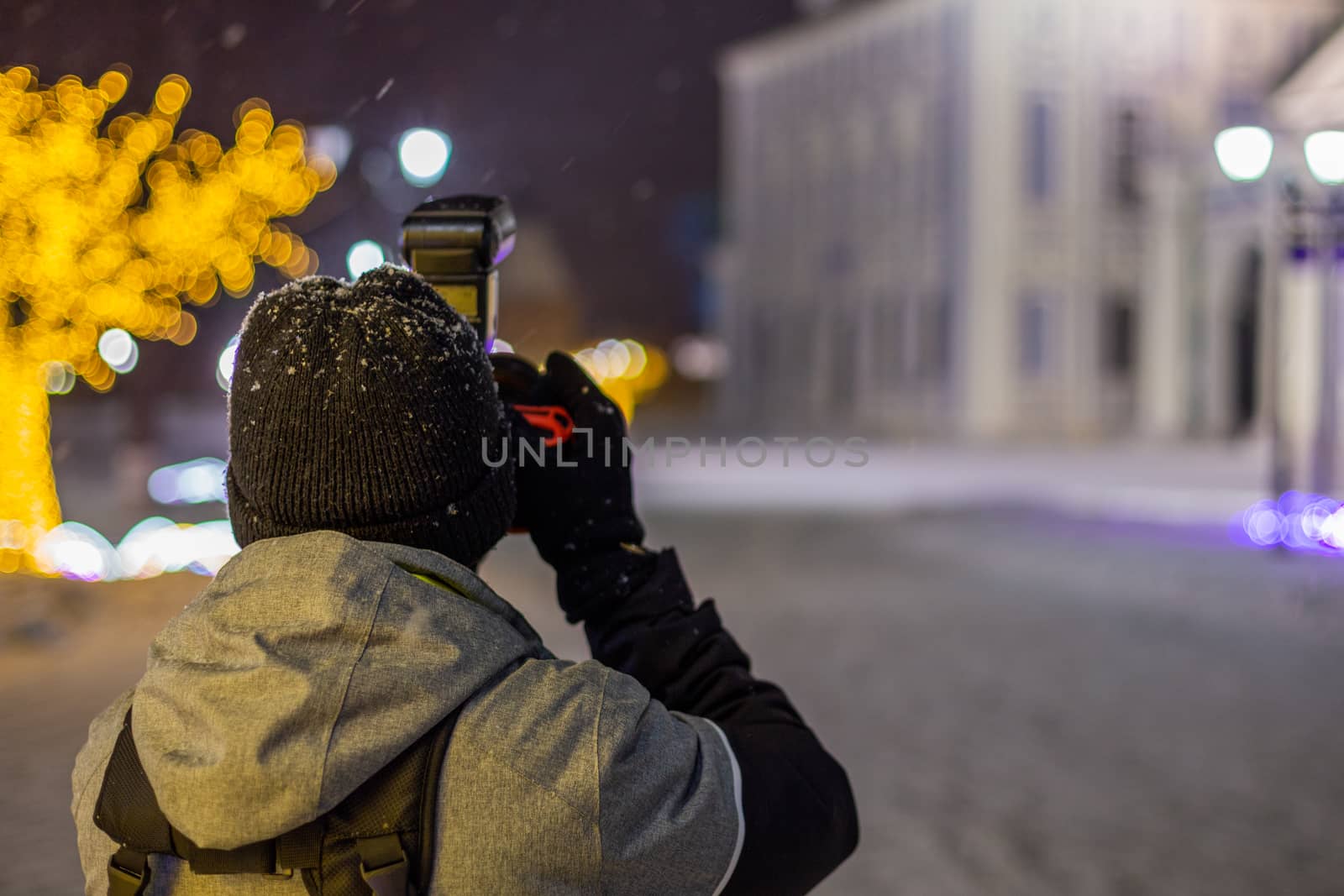 professional photographer shooting night architecture view handheld at snowy winter with natural light and selective focus