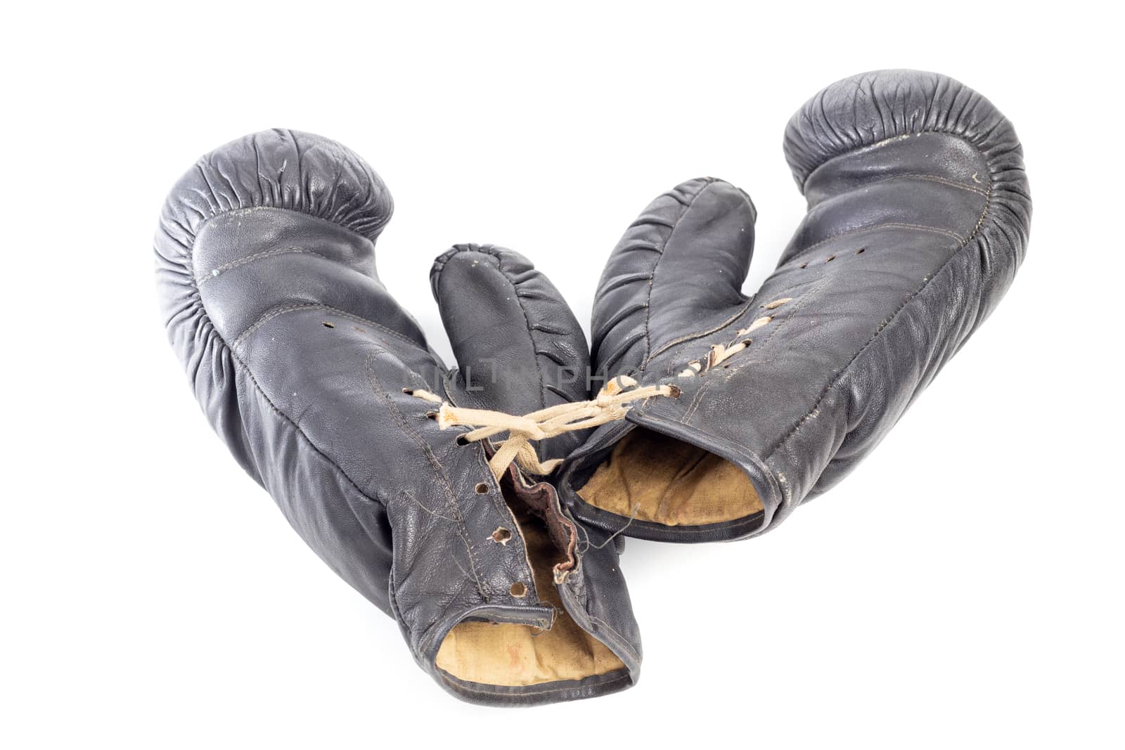 Old black leather boxing gloves isolated on white background with shadows lying on flat surface. Horsehair stuffed.
