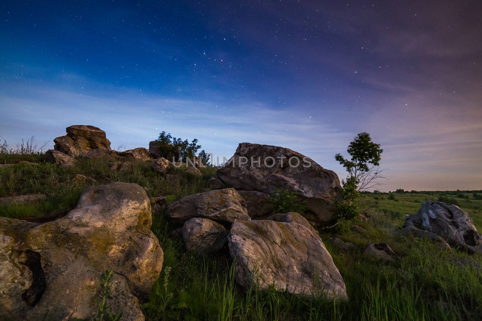night glacial stones in field landscape under moonlight