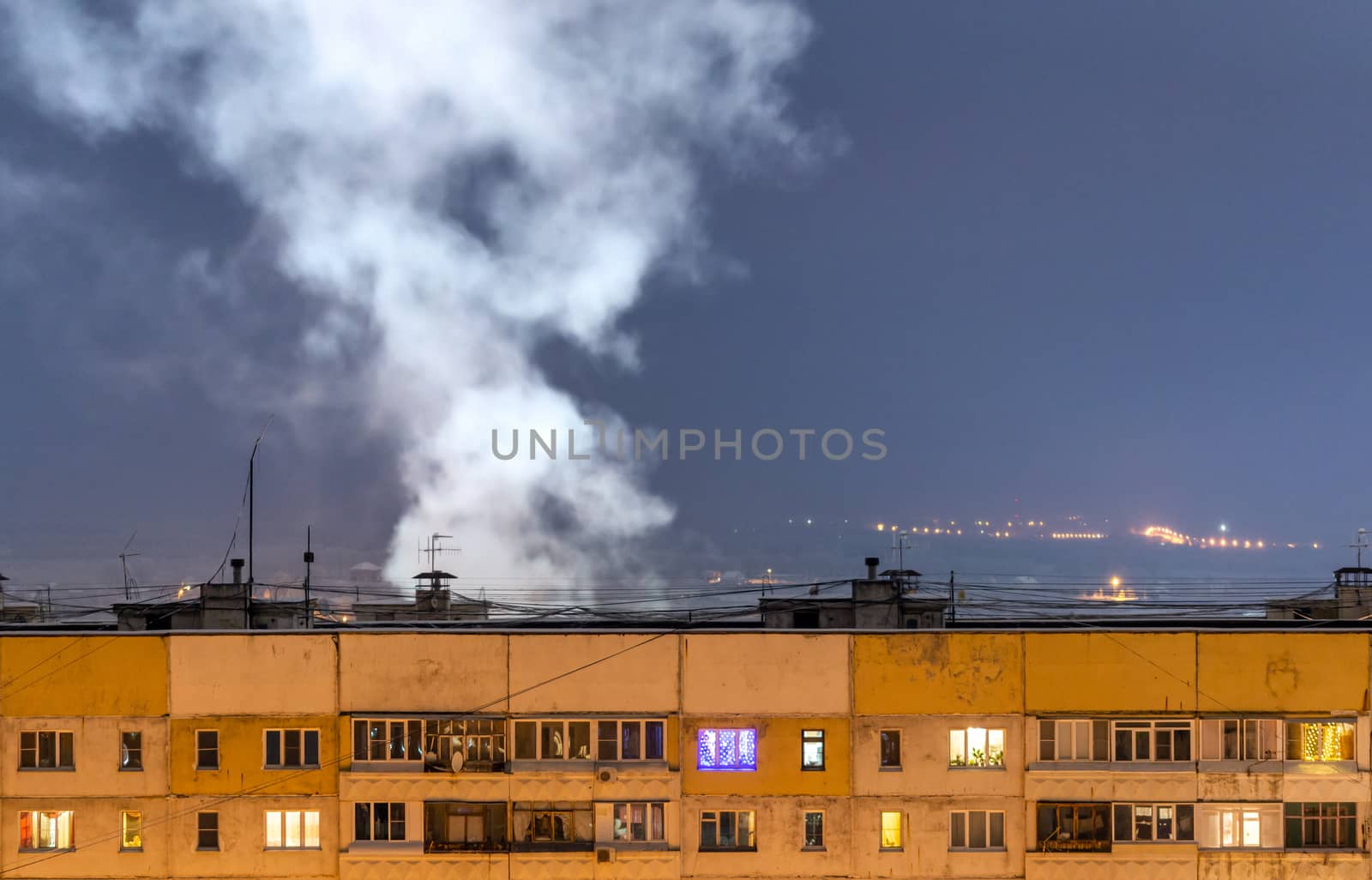 russian province high rise block houseroof with steam cloud.