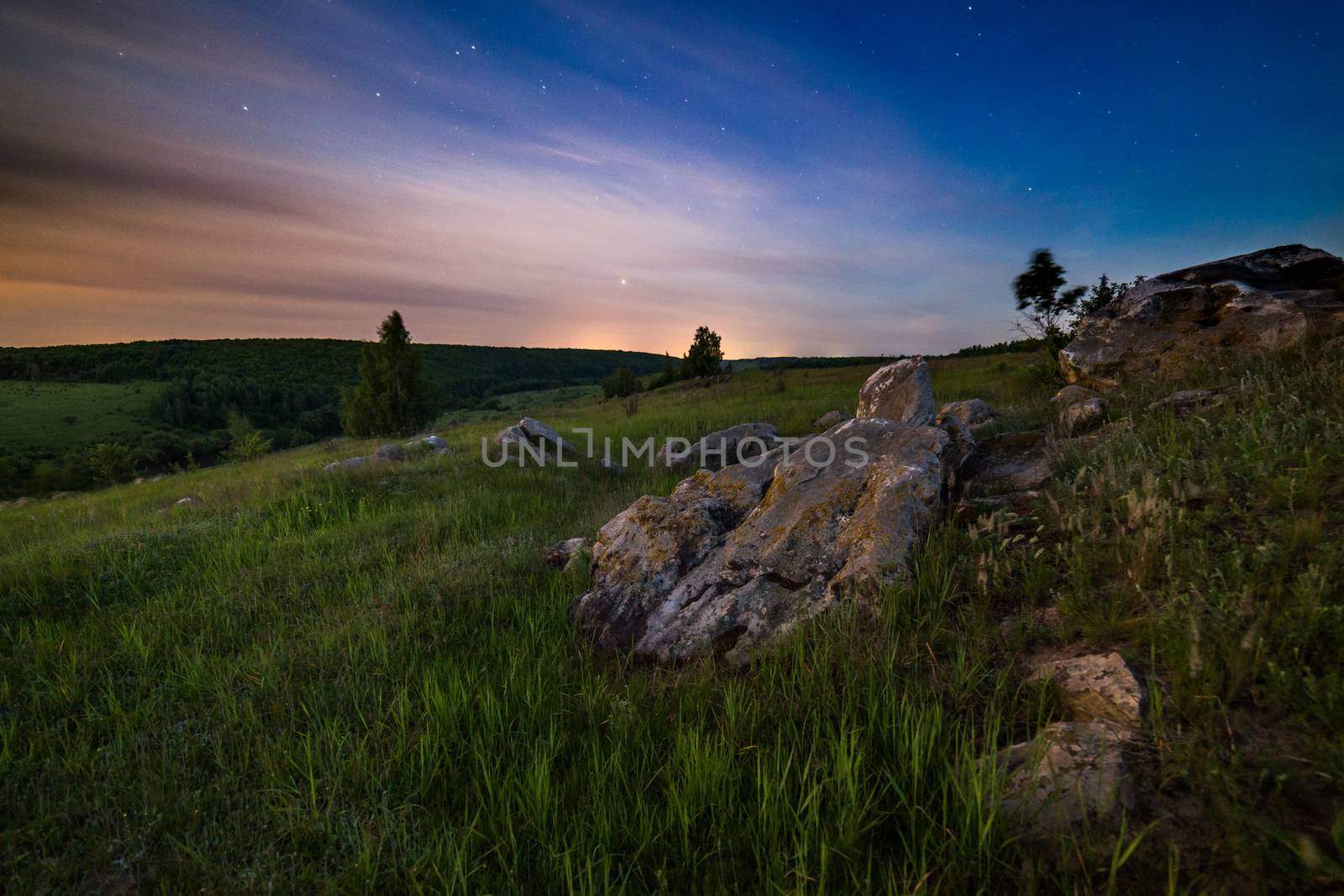 night glacial stones in field landscape under moonlight
