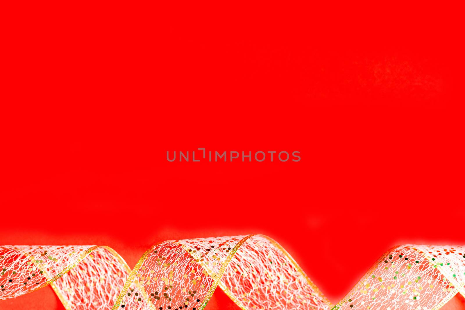 Golden ribbon against red background. gold packaging ribbon curls on red background, new year background, copy space, place for text, banner, holiday concept, Christmas, new year, Valentine's day by Pirlik