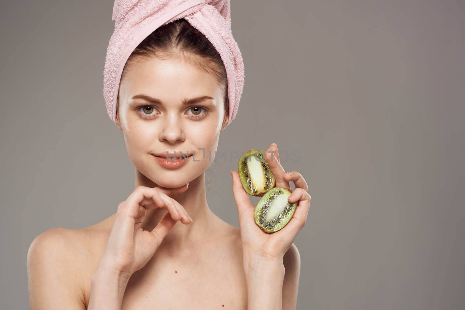 beautiful woman naked shoulders kiwi in the hands of spa treatments. High quality photo