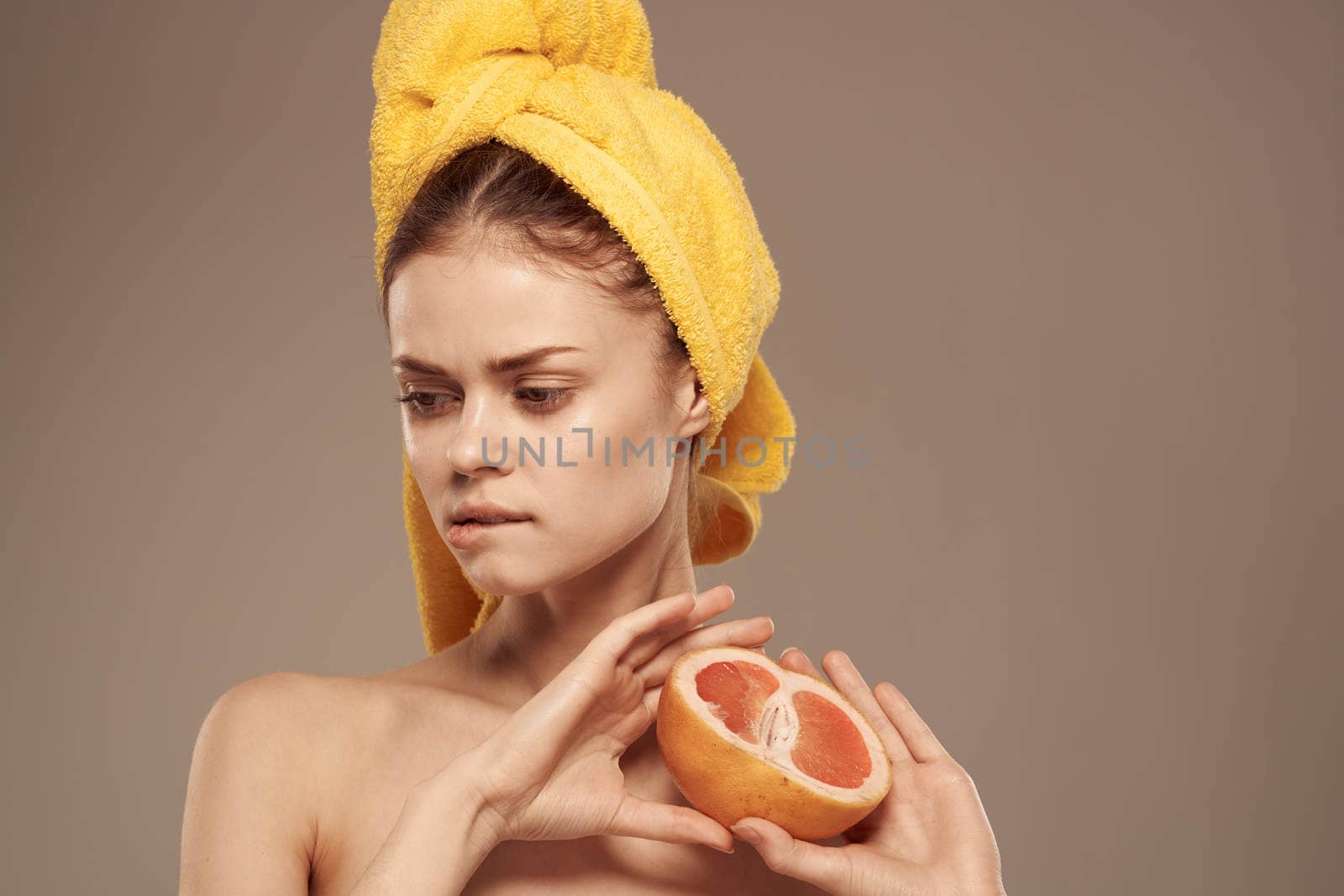 Pretty woman bared shoulders grapefruit in hand natural cosmetics vitamins. High quality photo