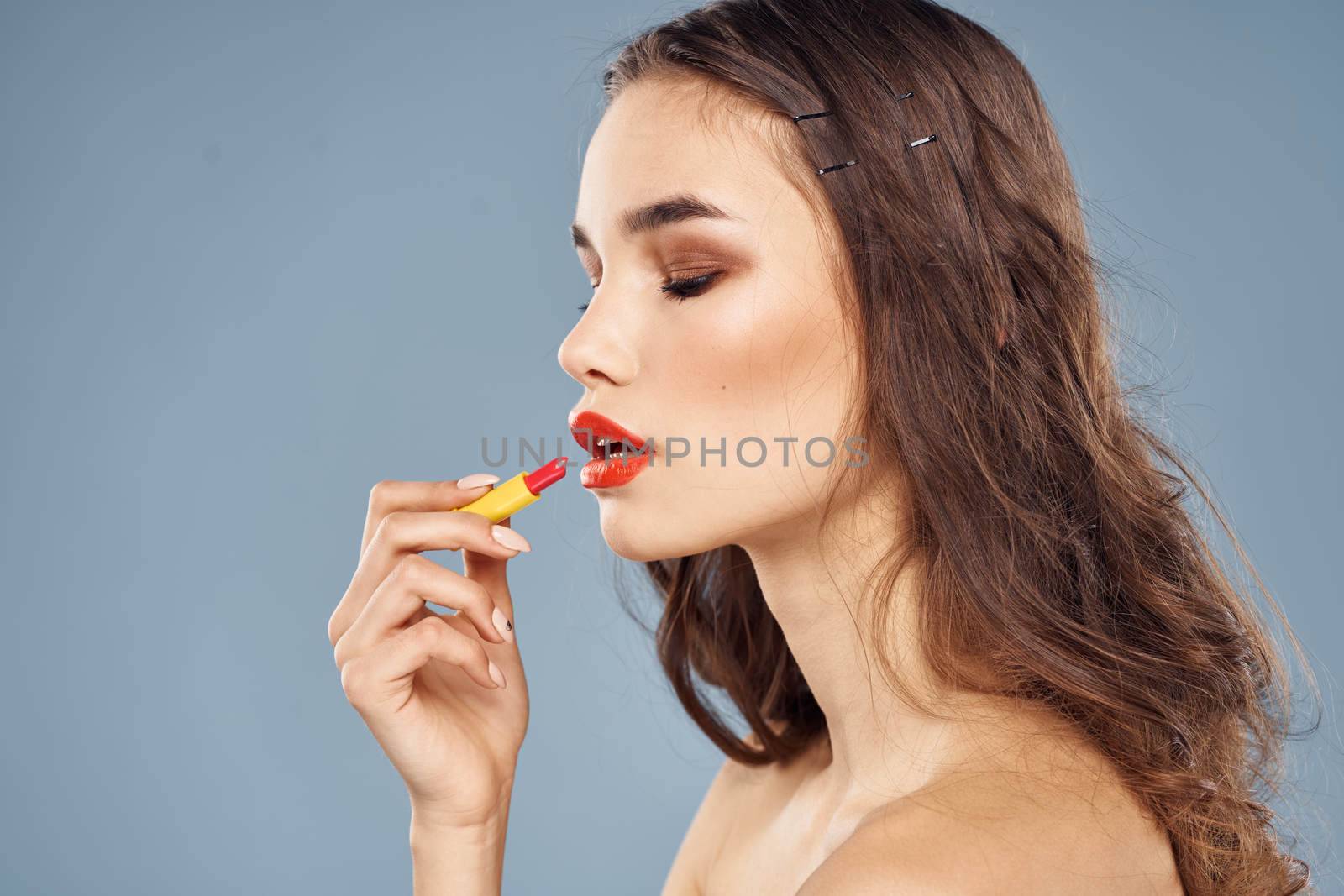 Woman with lipstick on a gray background brunette makeup with eye shadow on the eyelids. High quality photo