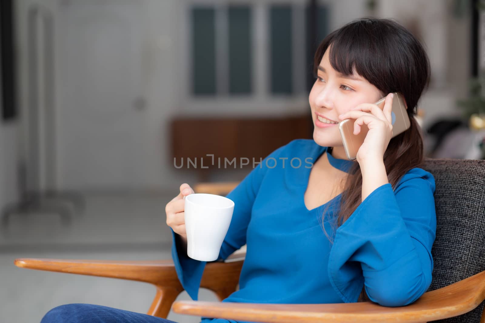 Beautiful portrait young asian woman smiling using mobile smart phone talking enjoy and drink coffee with relax, girl sitting on chair, communication concept.