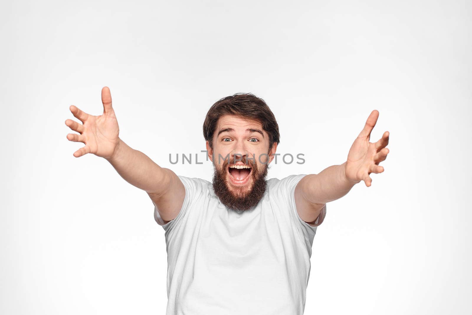 cheerful emotional bearded man gesturing with his hands close-up light background. High quality photo