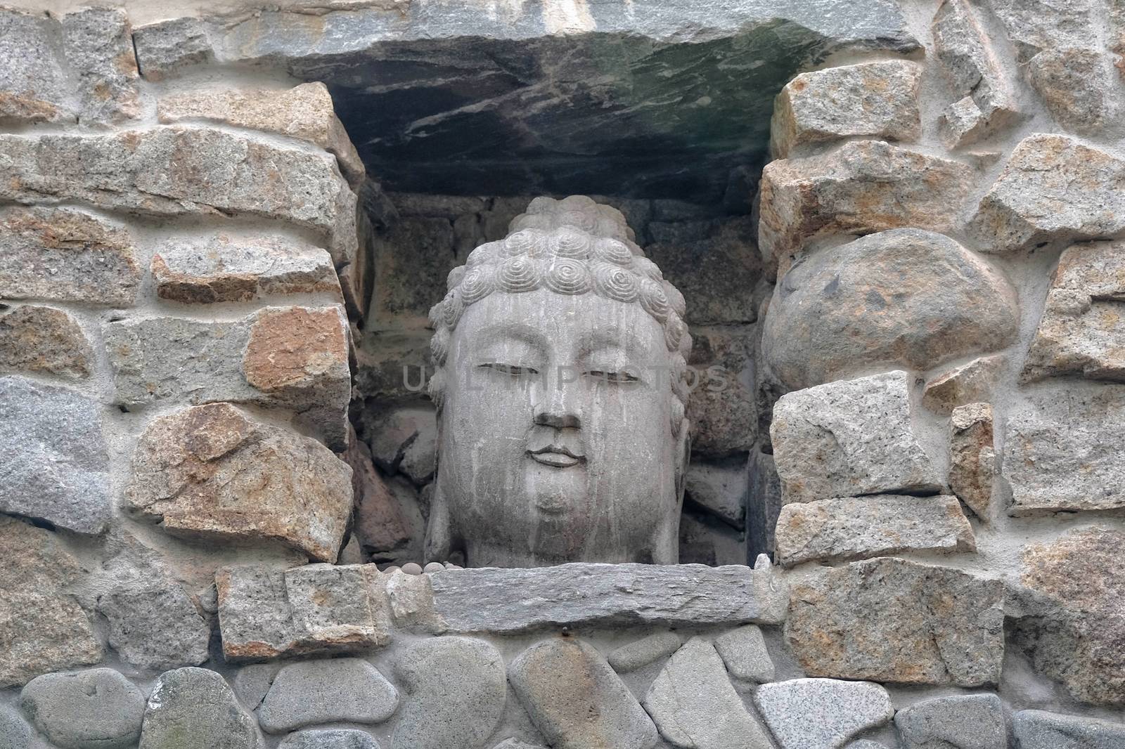 Closeup of Teh Buddha Head stone statue at entrance gate in Haedong Yonggungsa Temple at Busan, South Korea.