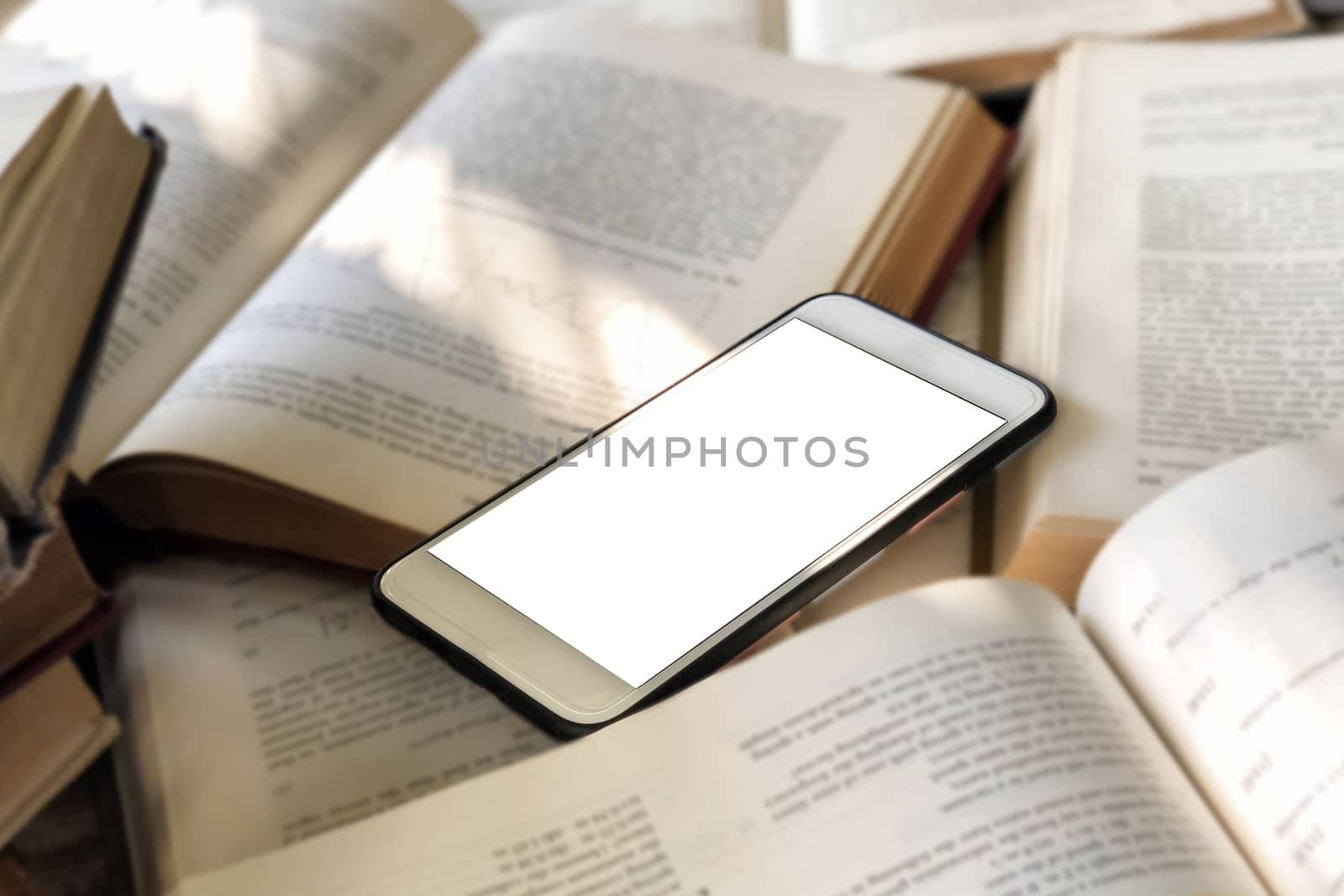 Books and smartphone in library  by Surasak