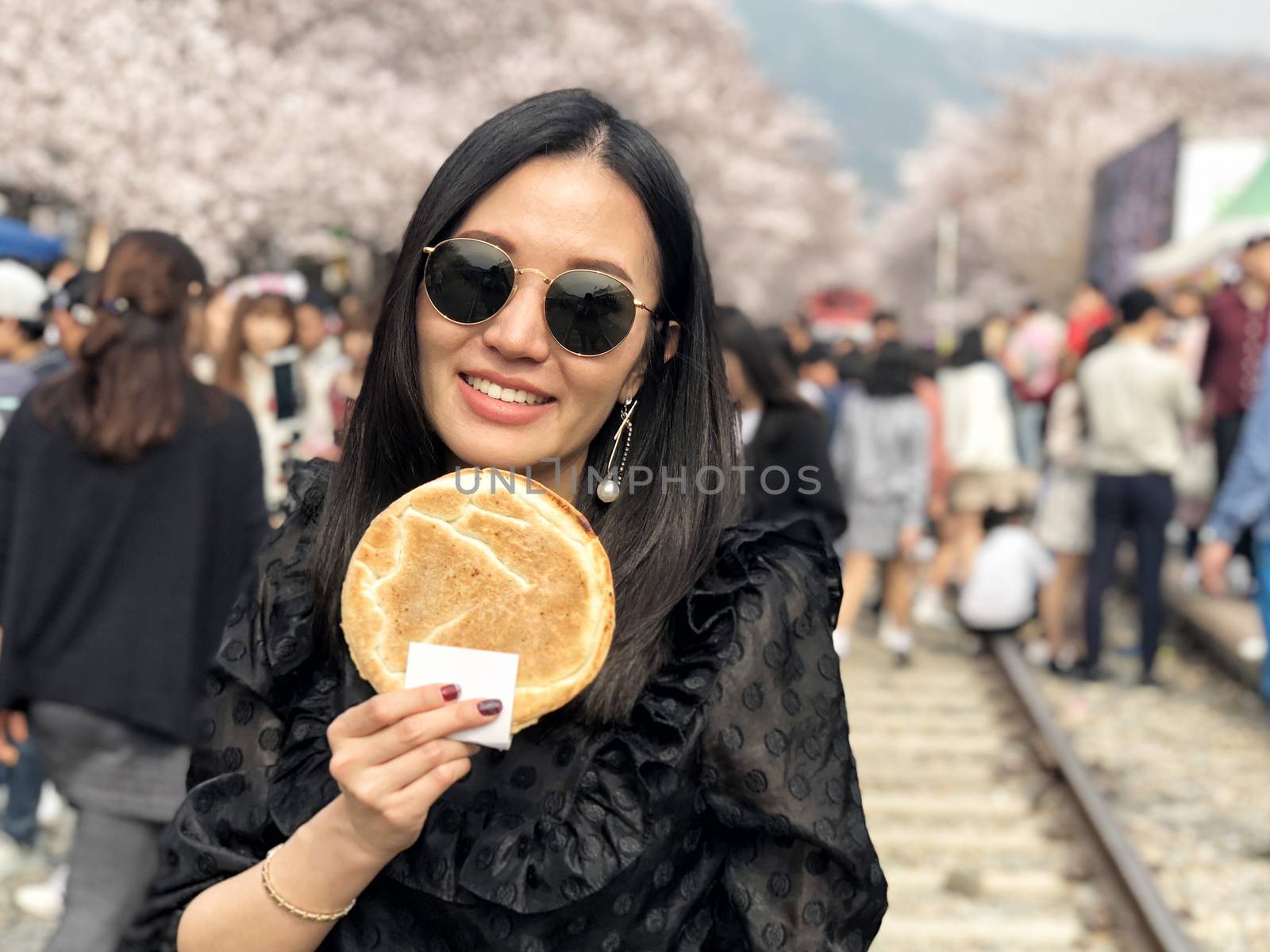 Woman eating Egg bread dessert at Jinhae Gunhangje Festival street food in Seoul, South Korea