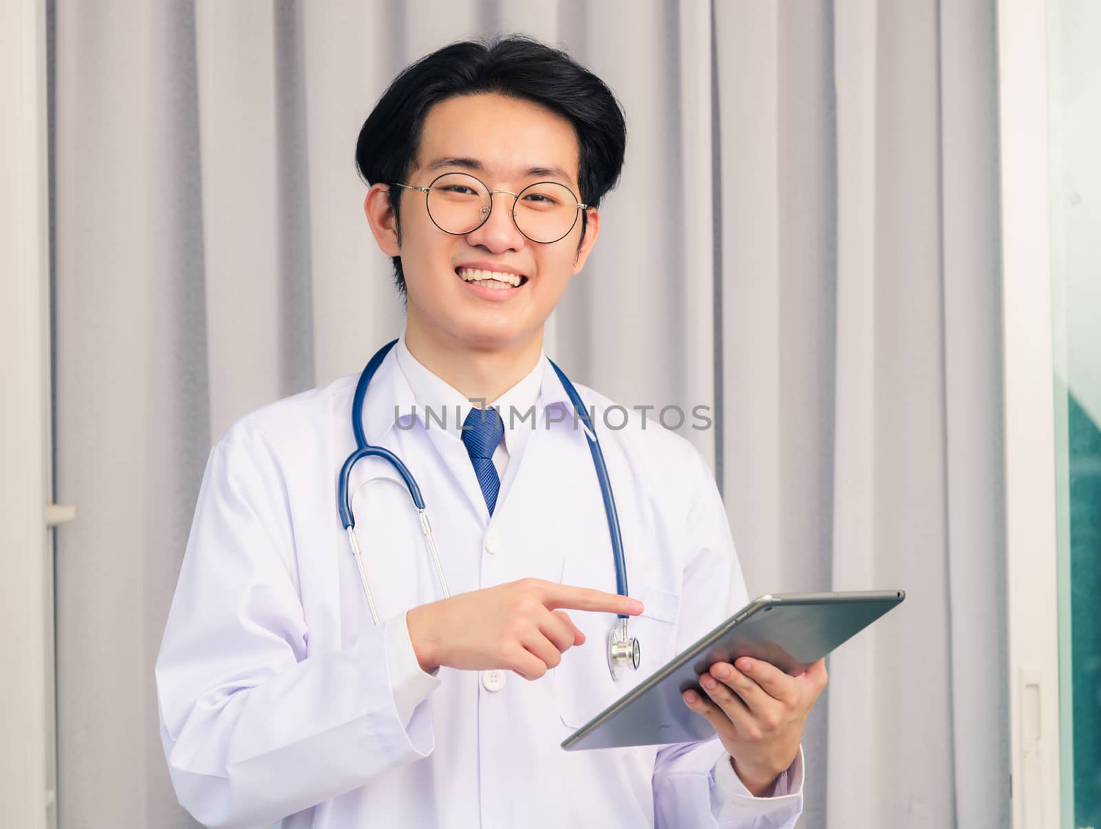 Doctor man smiling and stethoscope neck strap point smart digita by Sorapop