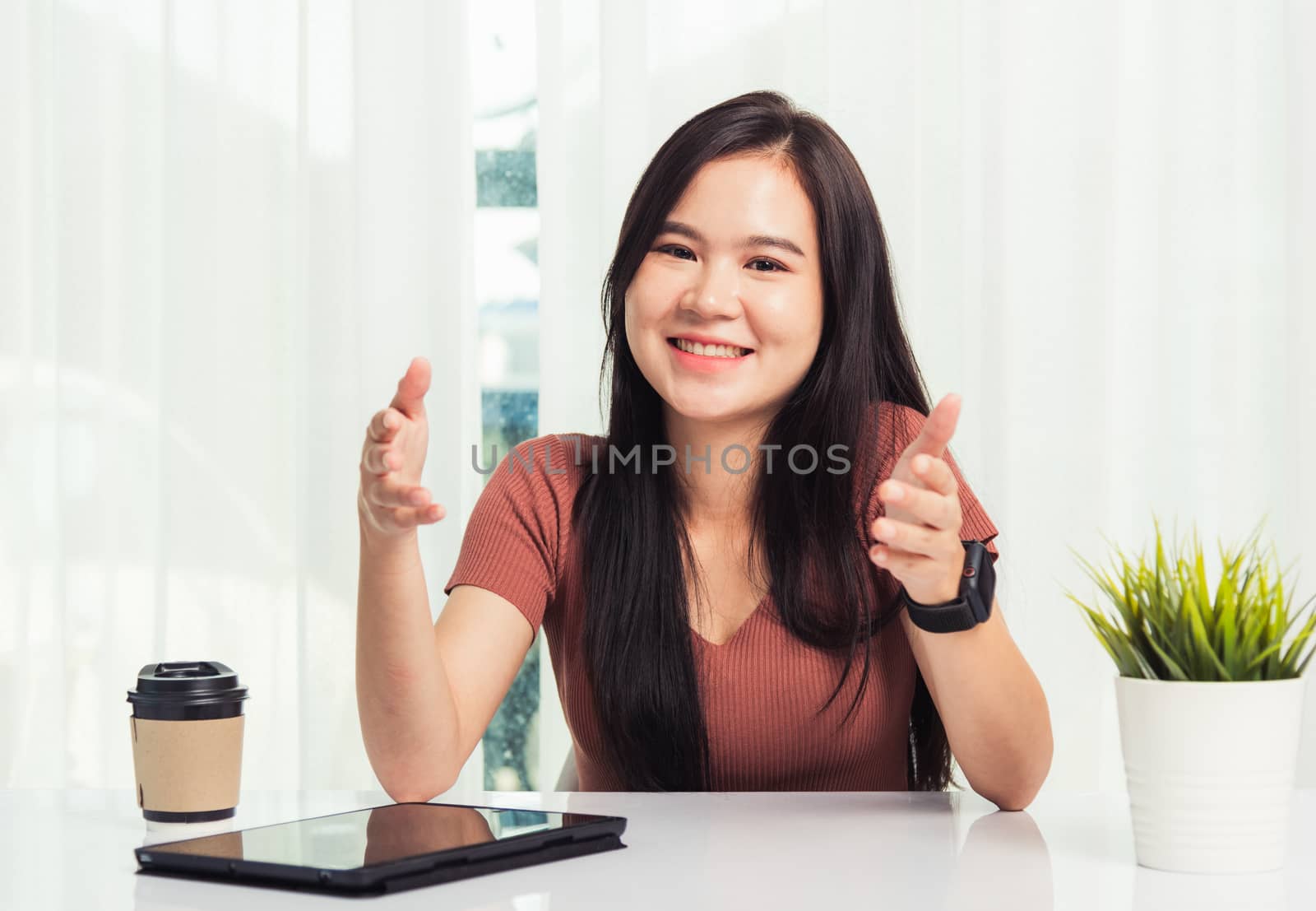Beautiful woman smiling sitting on desk workspace talking commun by Sorapop