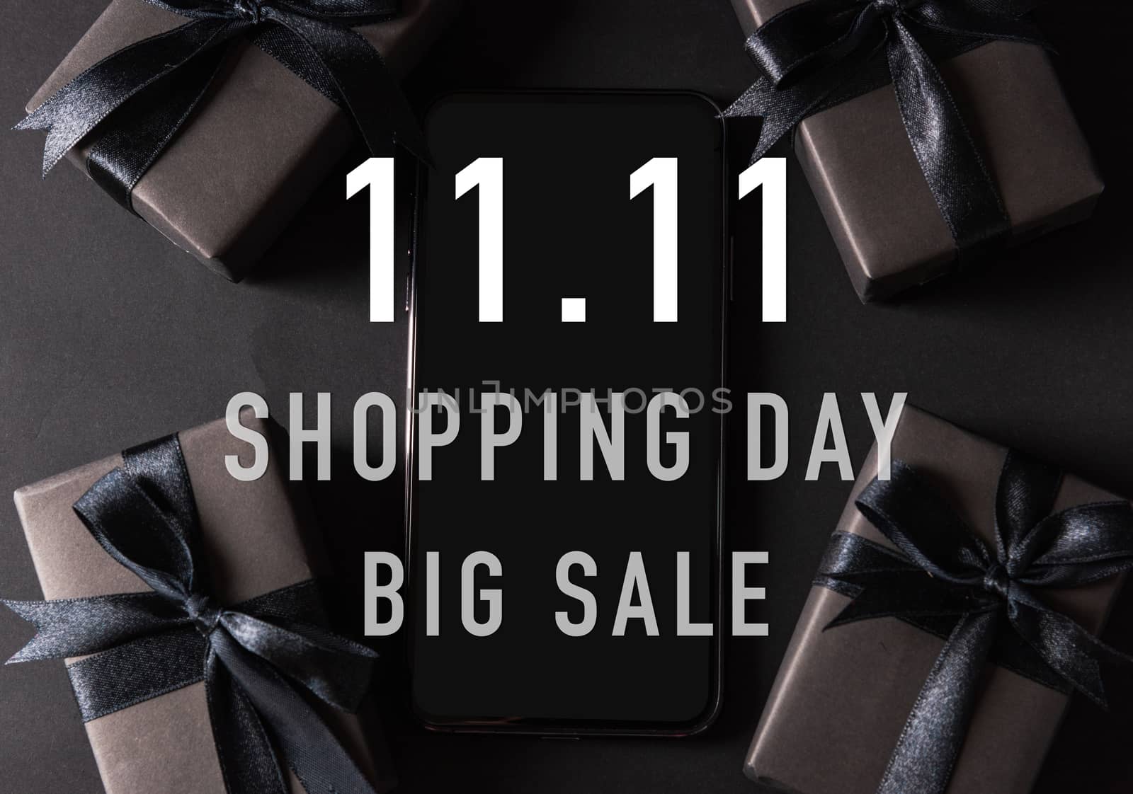 11:11 sale shopping concept, Top view of gift box wrapped black paper and black bow ribbon present around a smartphone with 11.11 shopping and big sale text, studio shot on dark background11:11 sale shopping concept, Top view of gift box wrapped in black paper and black bow ribbon with 11.11 single's day and big sale text at the side space, studio shot on dark background