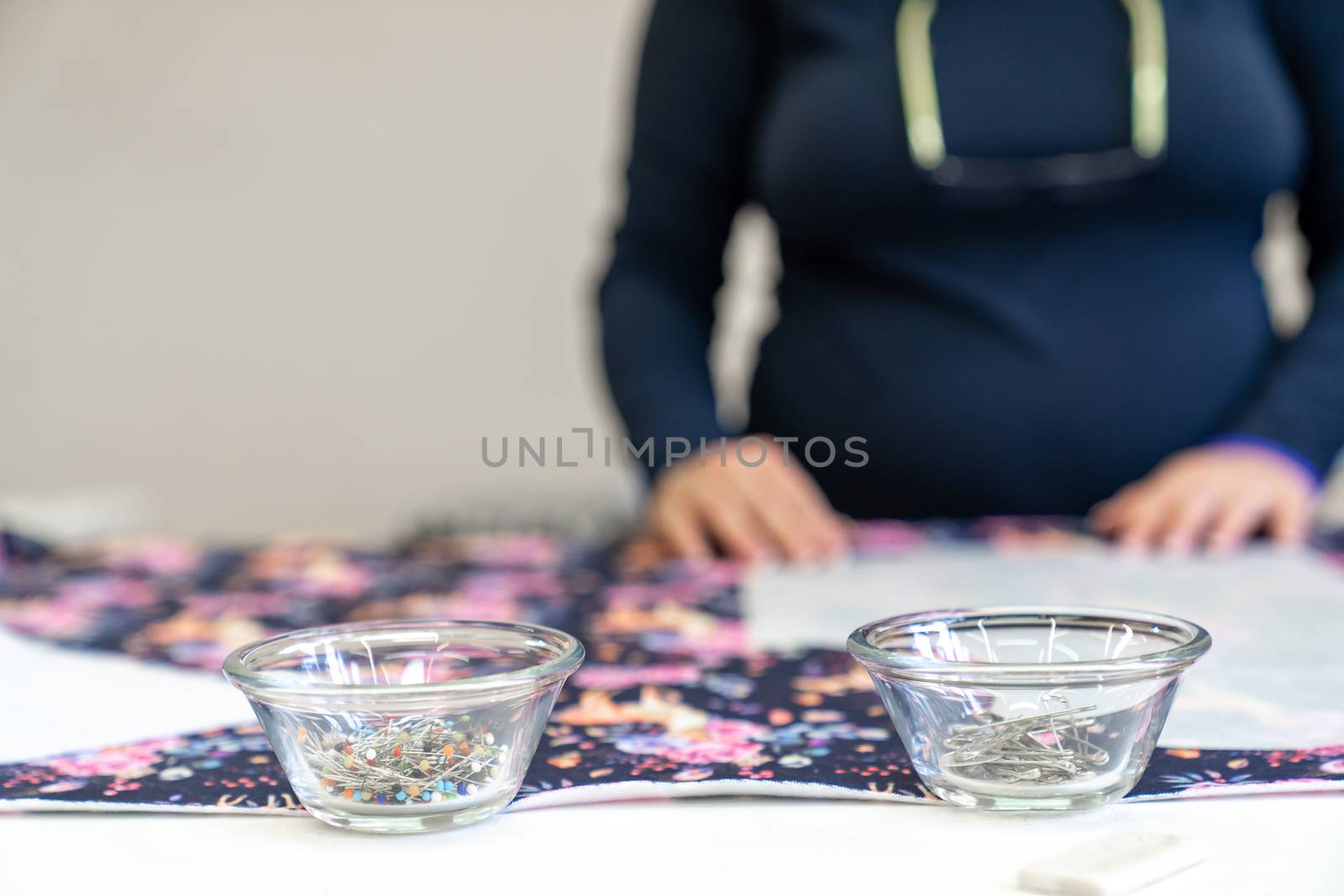 needles in a bowl on a sewing table in a tailor shop.