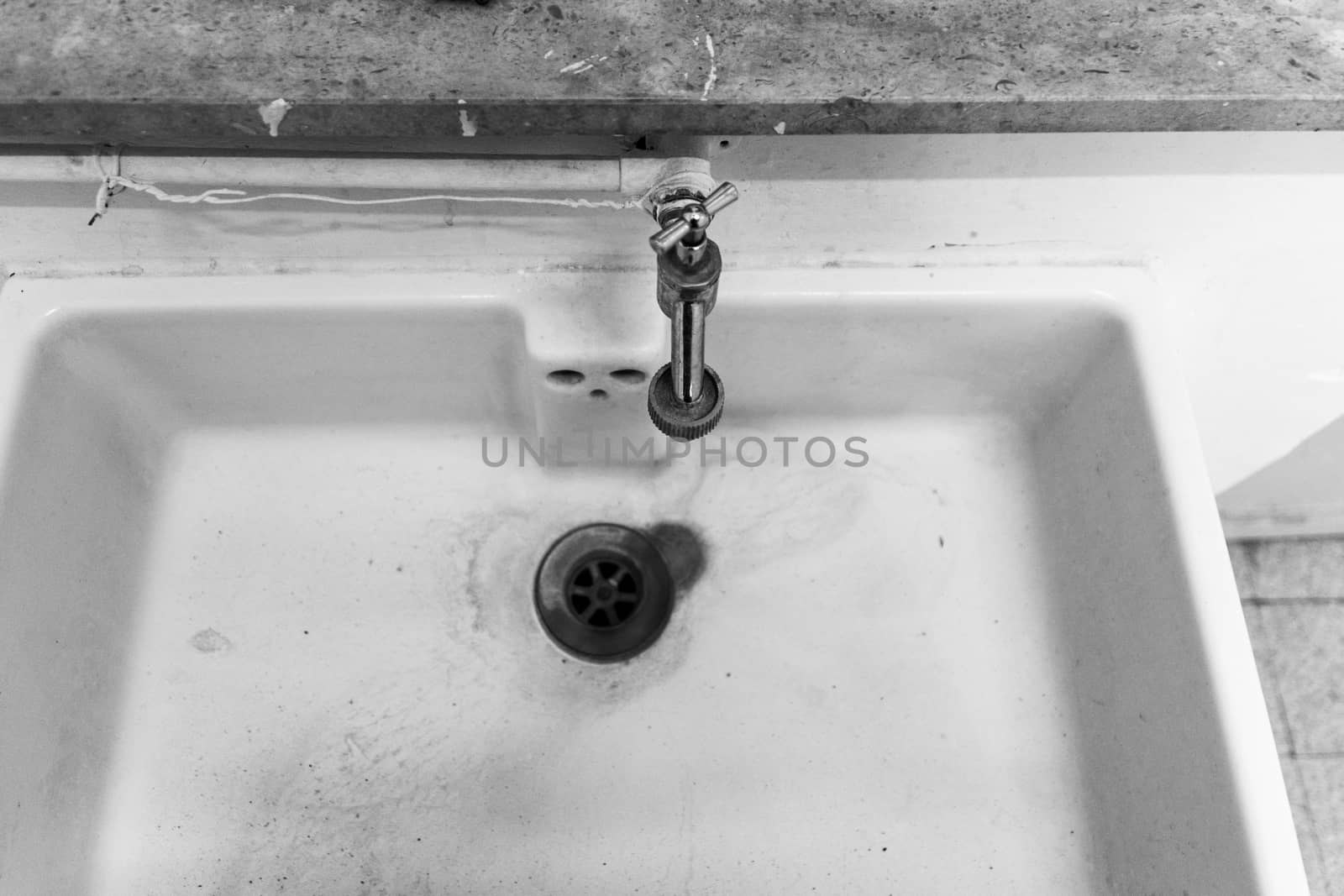 Black and white of old and dirty empty sink stone with drain water tap or faucet by kb79