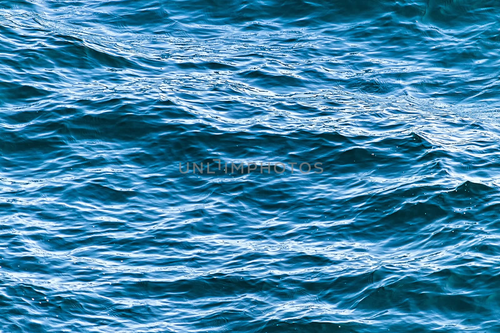 Blue seawater waves of sunligt. Top view. by Essffes