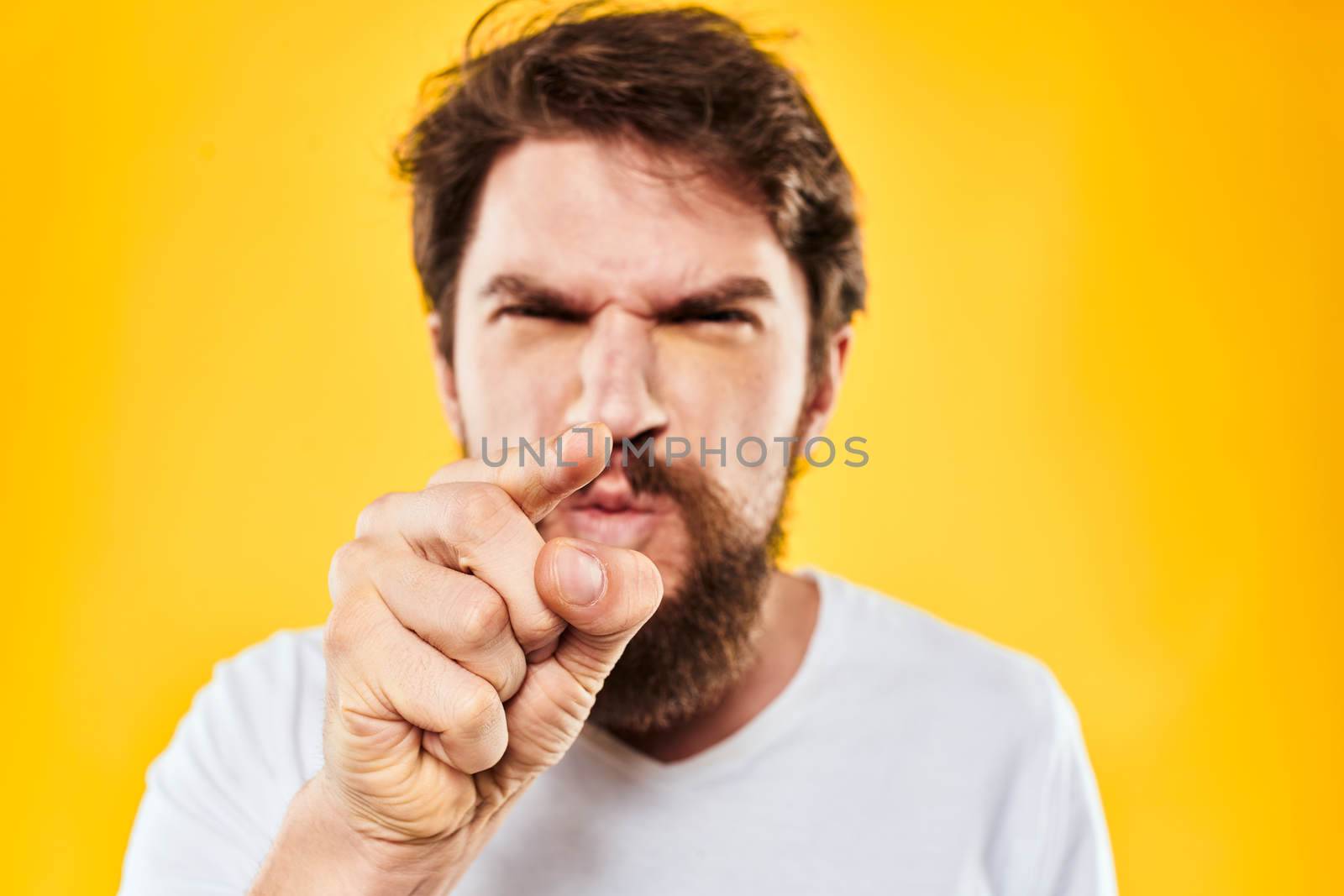 bearded man gesturing with hands studio lifestyle discontent yellow background by SHOTPRIME