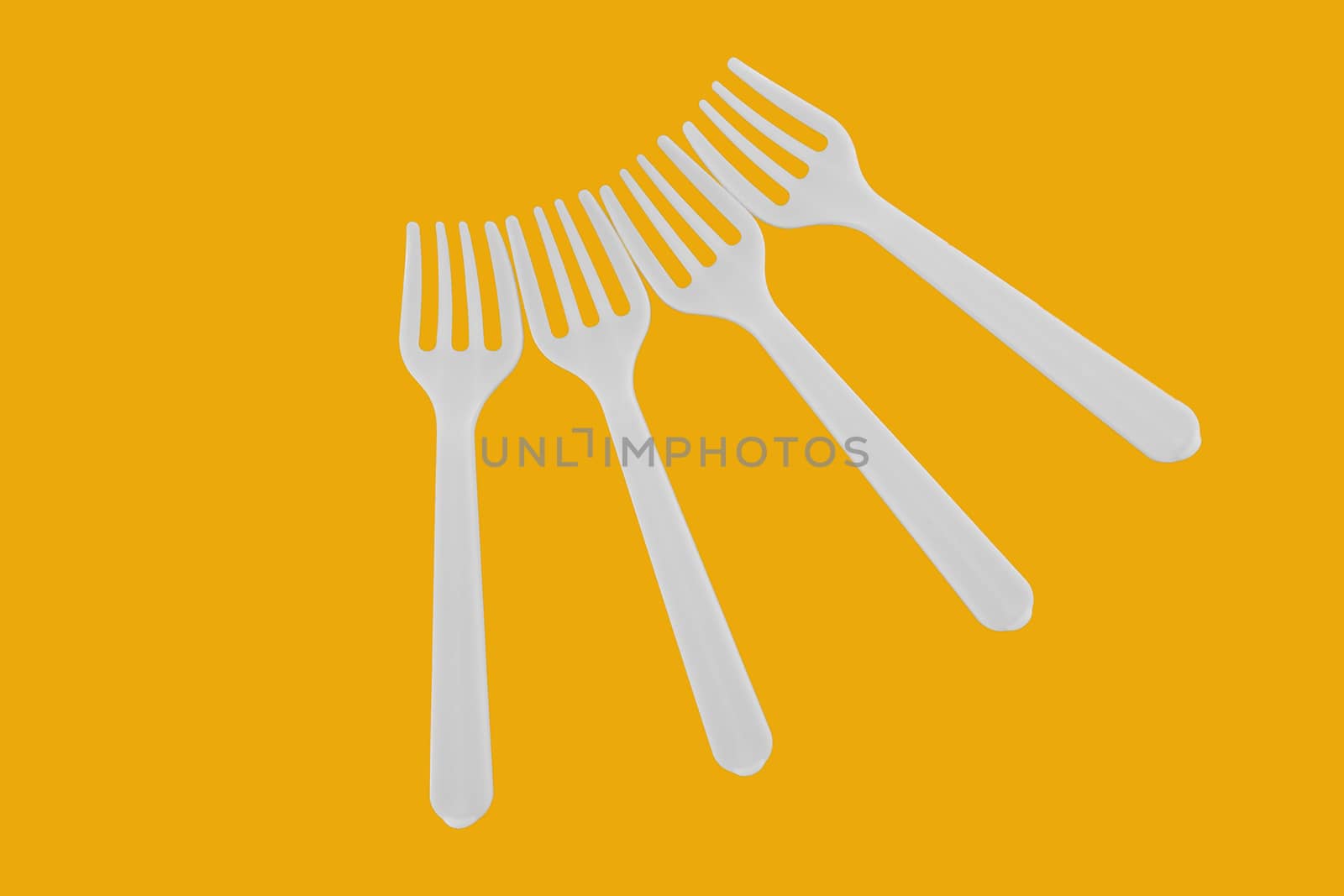 four plastic white forks on background