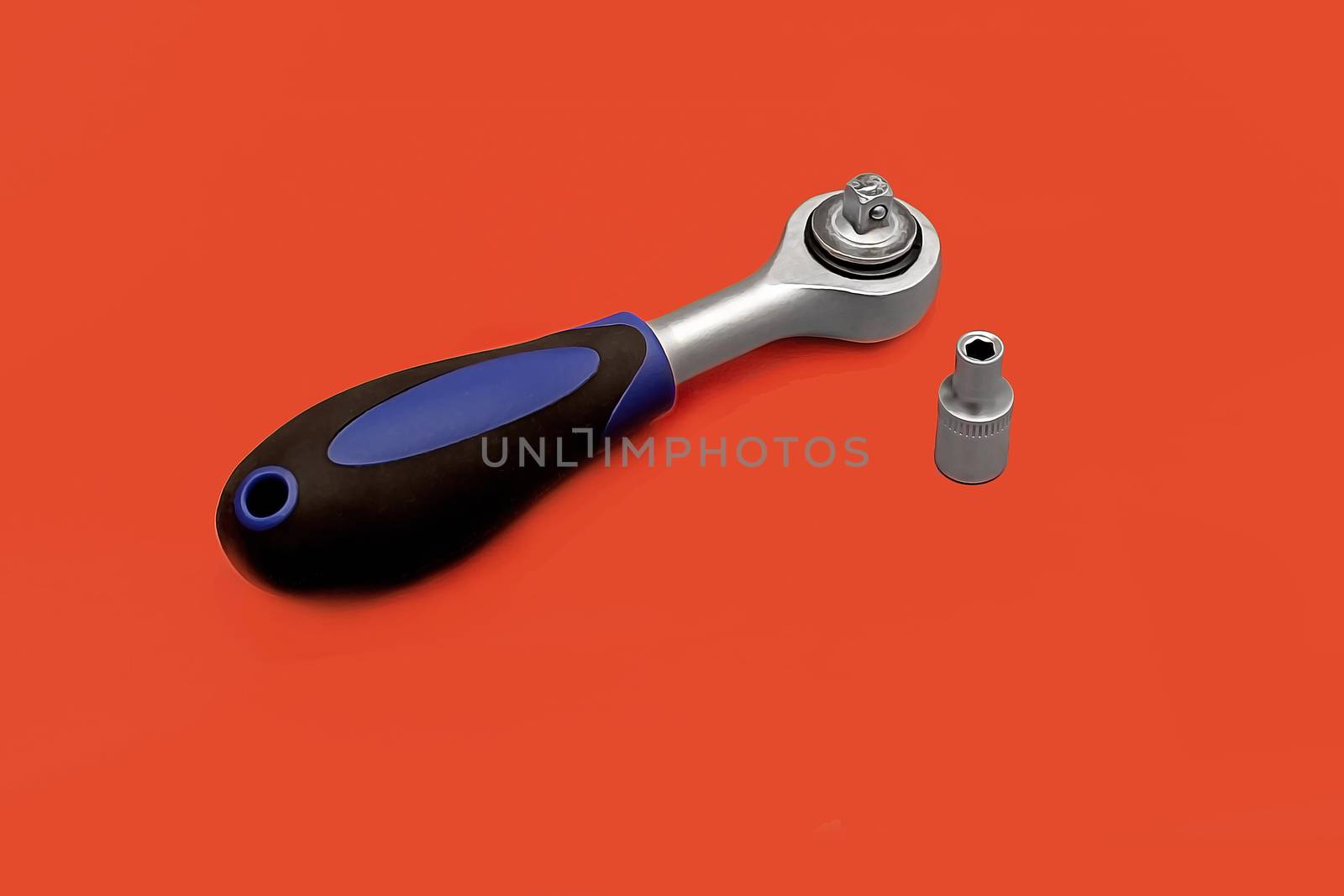 Tools for work, semi-automatic screwdriver with black plastic handle on red background.