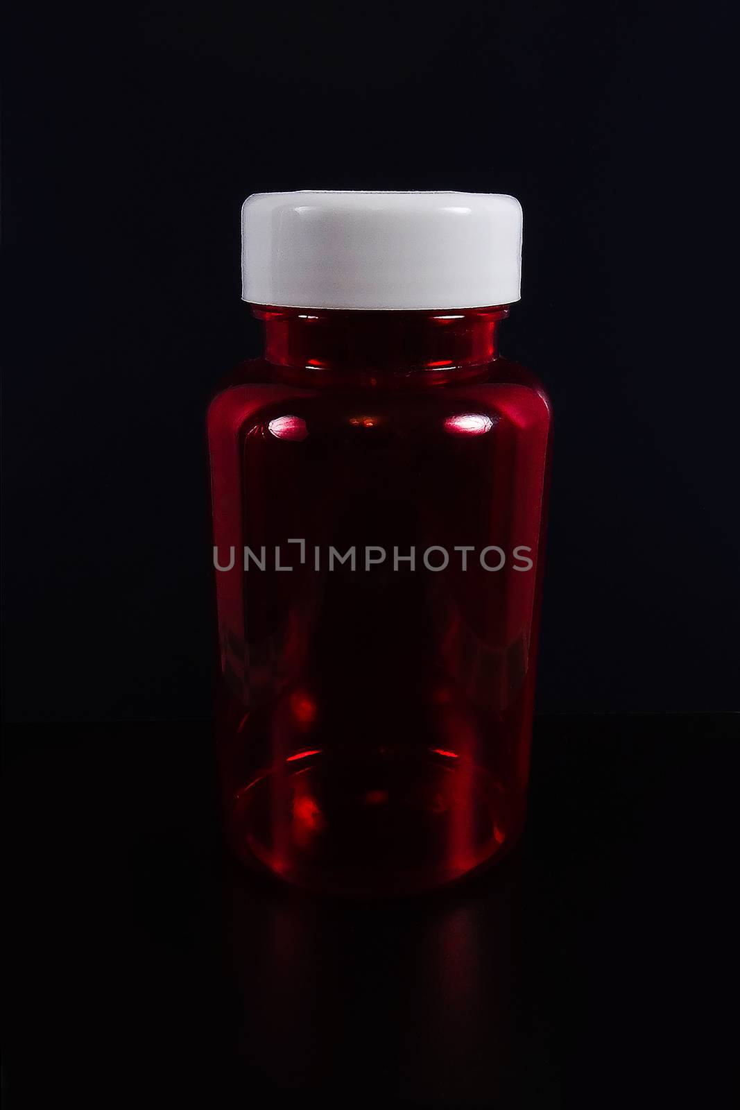 A jar of pills on a black background