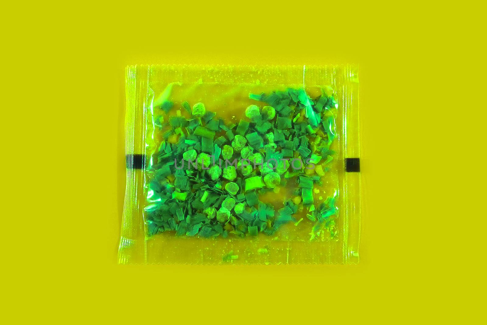 Plastic bag with spices on a yellow background