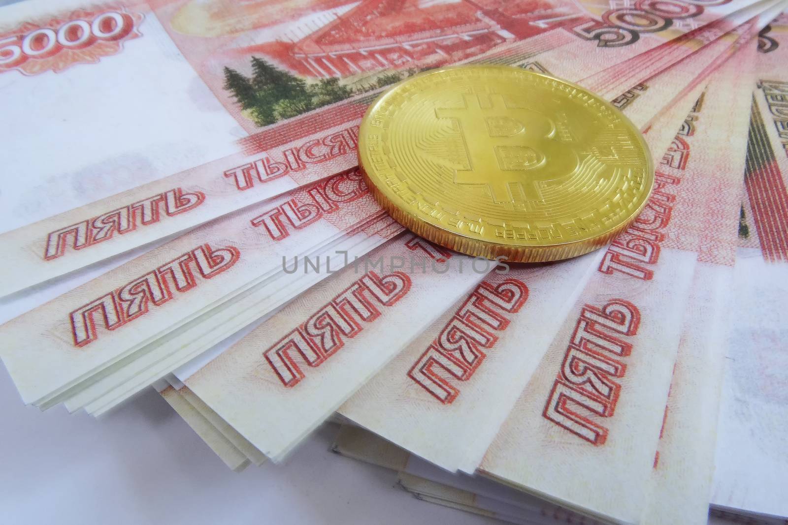 Bitcoin coin on a wad of money. Top view