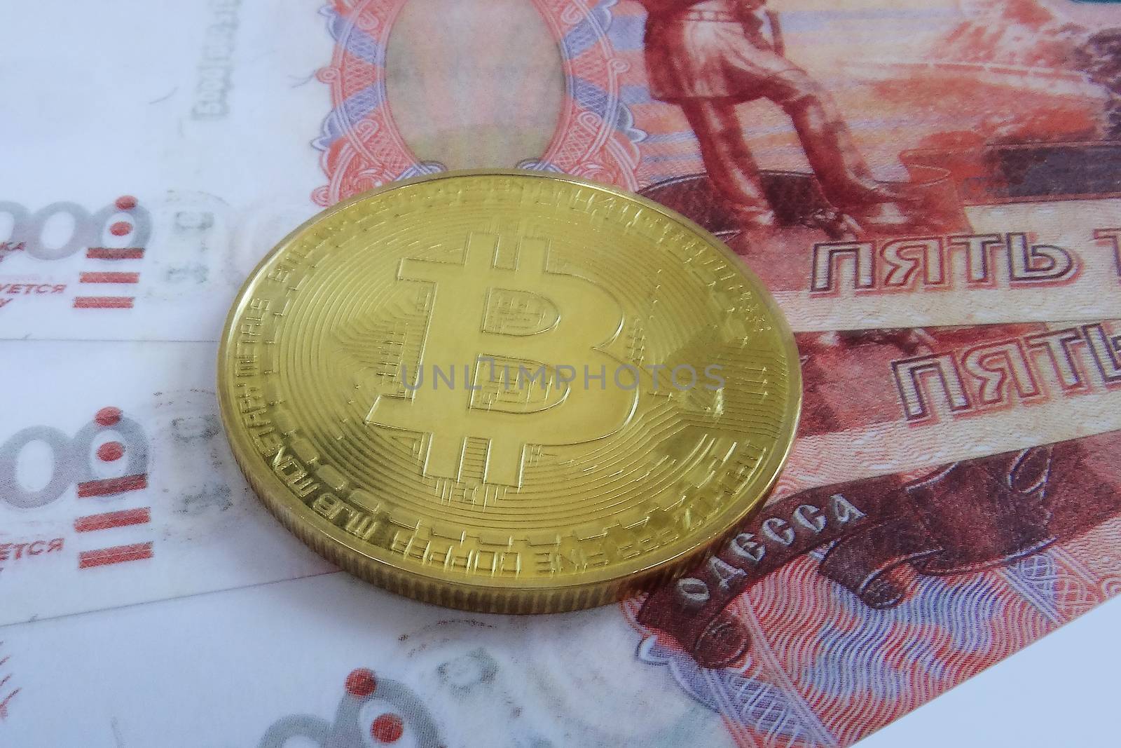 Bitcoin coin on a wad of money. Top view