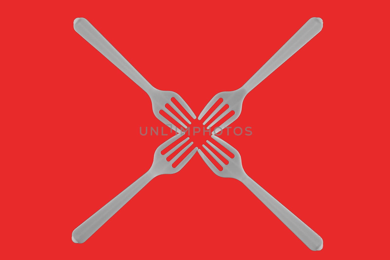 four plastic white forks on a red background