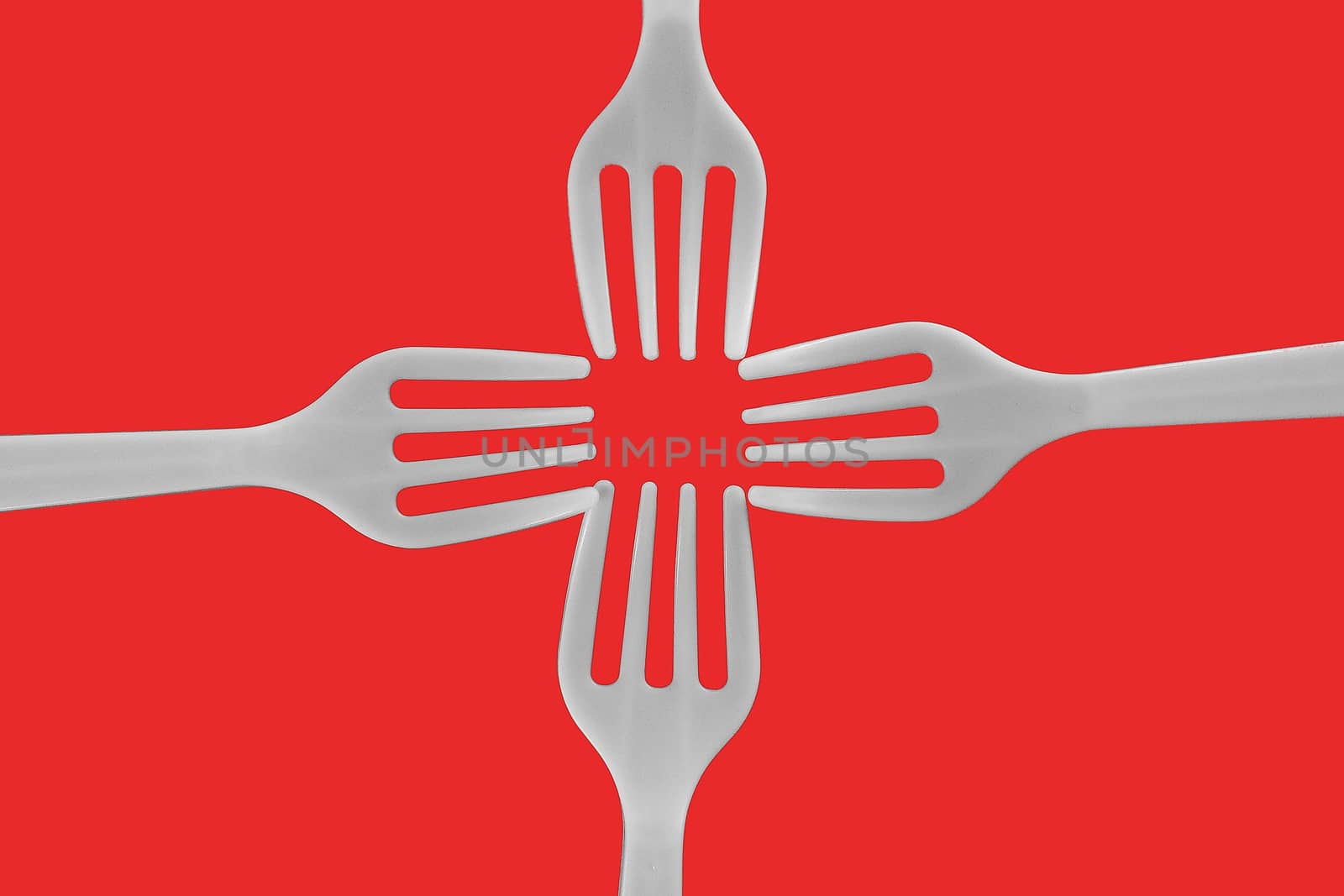 four plastic white forks on a red background