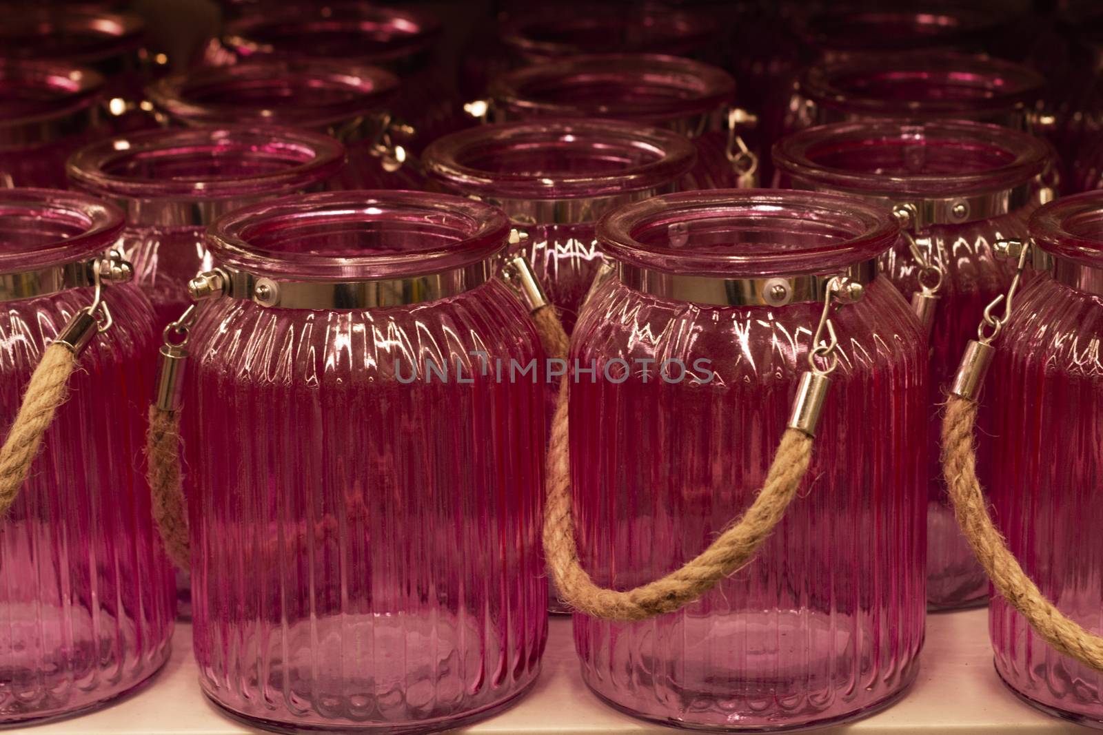 Pink glass jars with a handle. In A row.