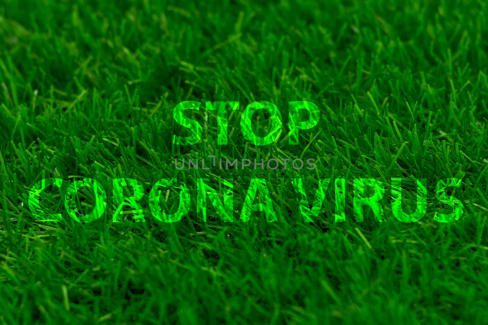 Stop corona virus against backdrop of green grass. Words.