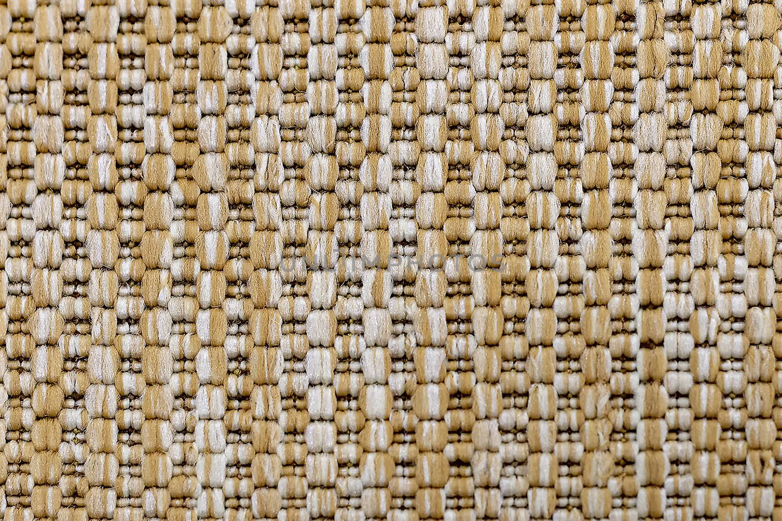 A knitted beige textile background. Fragment. View from above.
