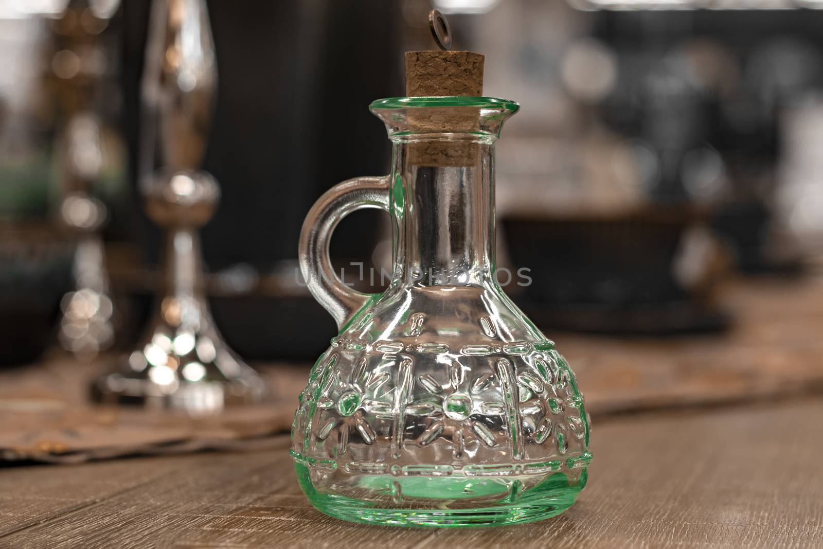 Glass transparent carafe with cork on served table.