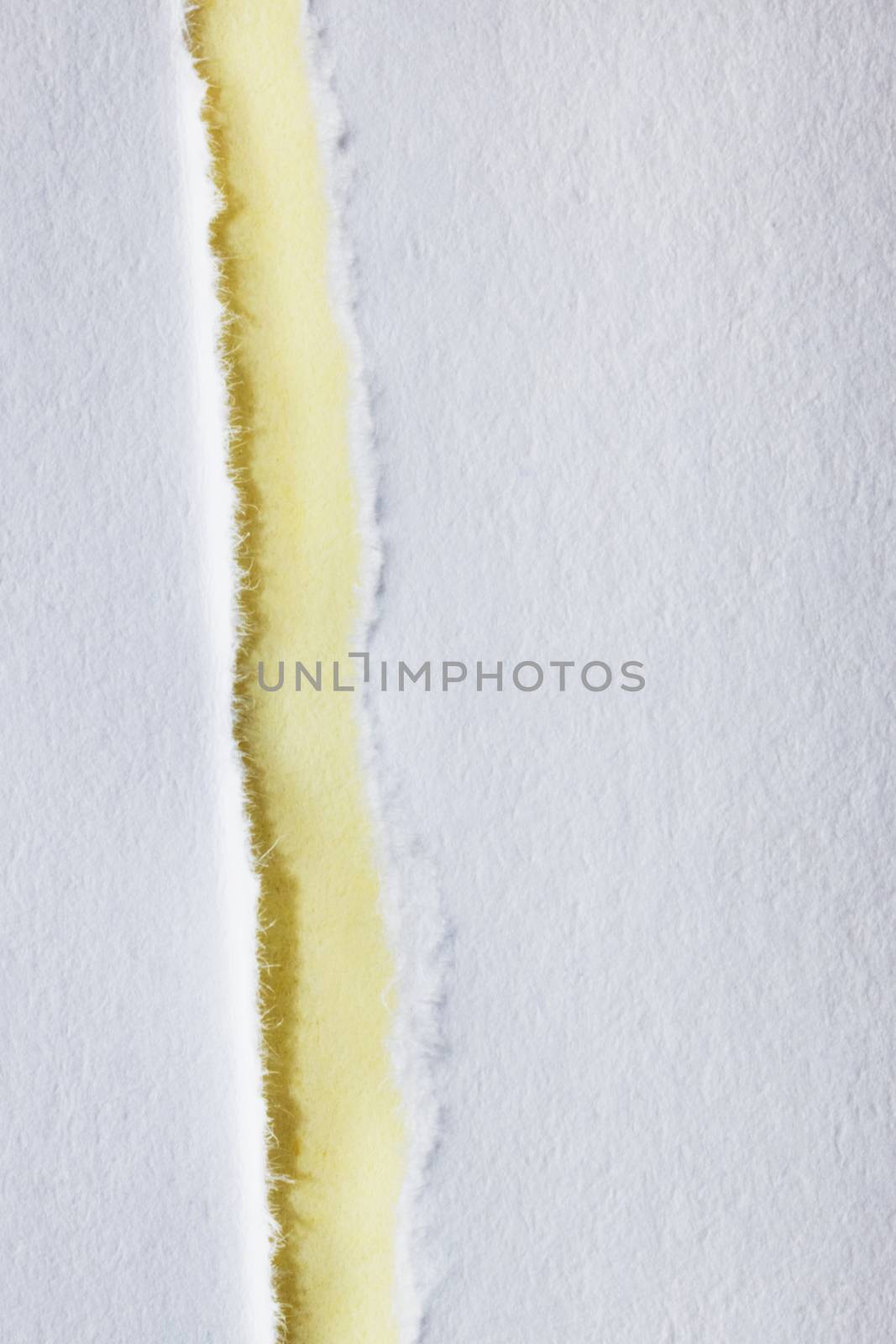 A white ripped paper rests on a yellow background ,beautiful paper edge , top view