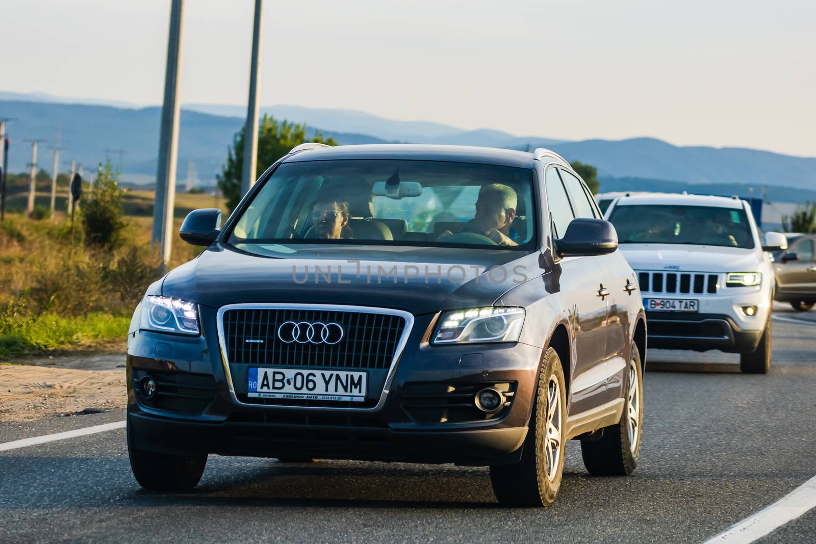 Traveling cars in motion on asphalt road, front view of cars in row on street. Bucharest, Romania, 2020