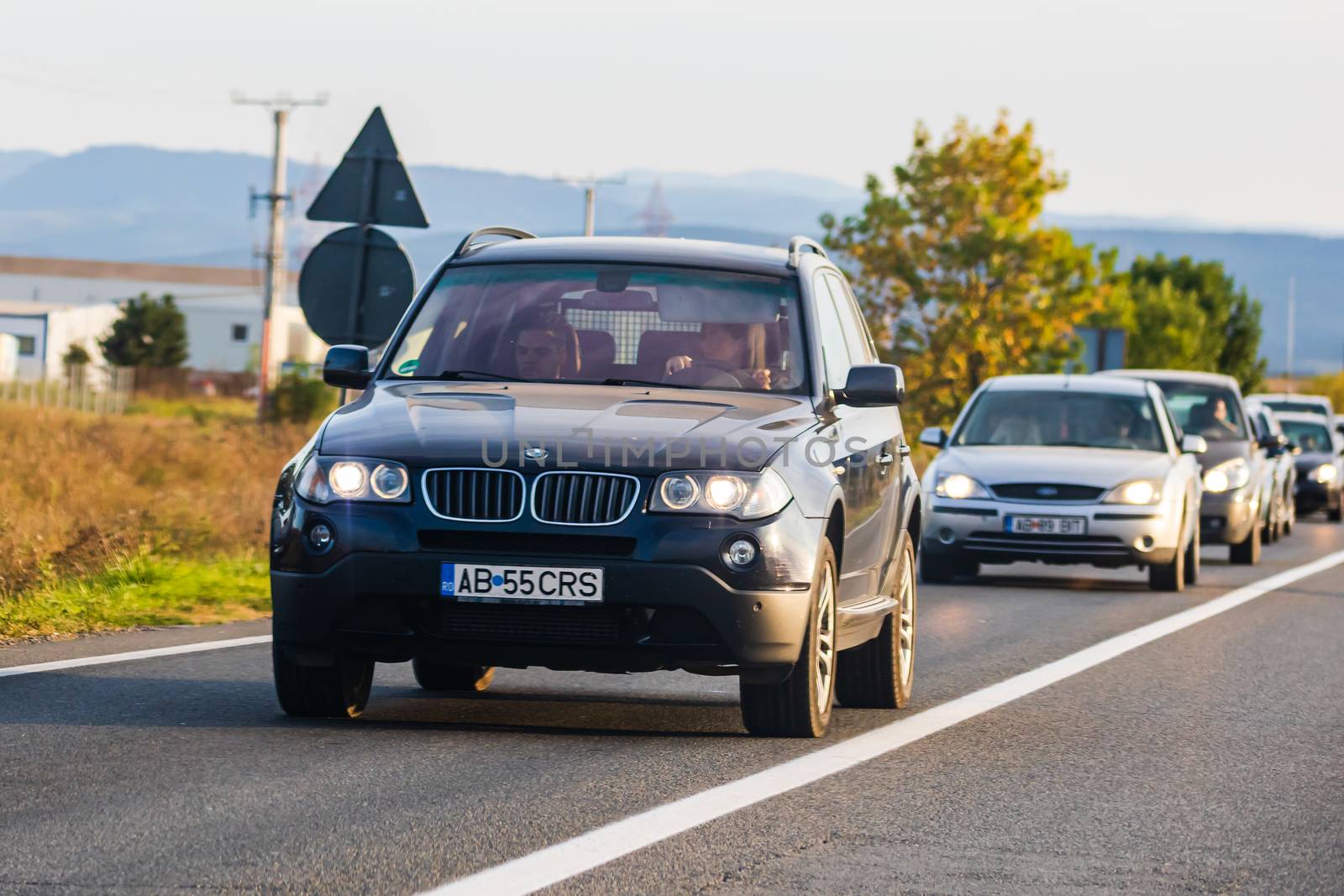 Traveling cars in motion on asphalt road, front view of cars in row on street. Bucharest, Romania, 2020