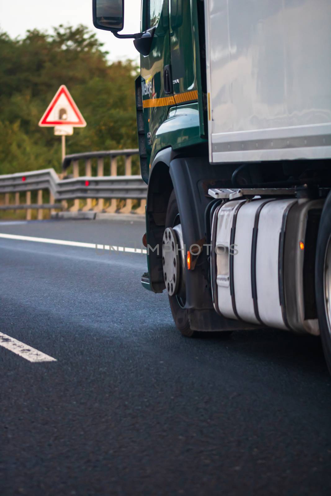 Side view of loaded European truck in motion on asphalt road, transportation and delivery concept. Detail on delivery truck. Bucharest, Romania, 2020