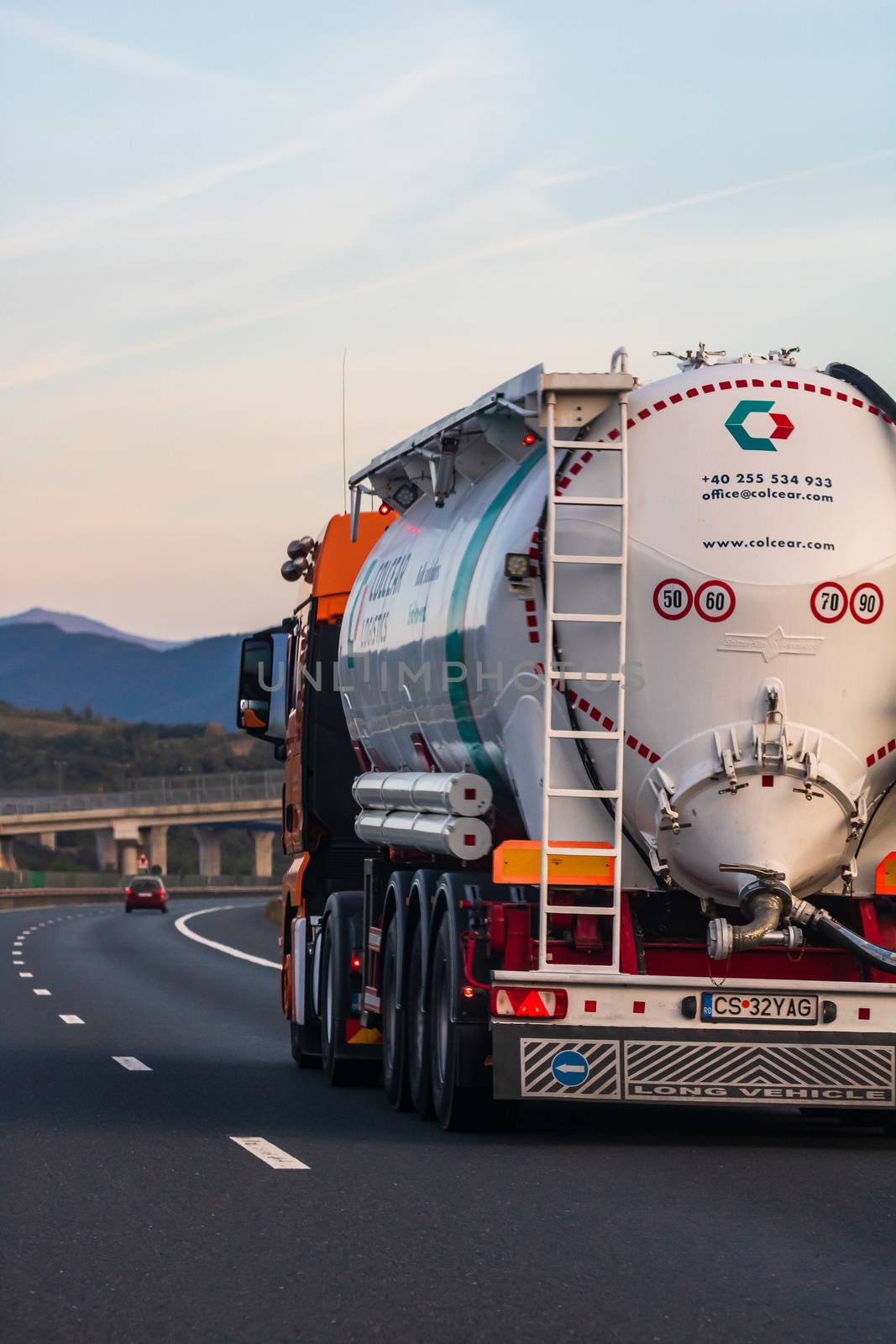 Side view of loaded European truck in motion on asphalt road, transportation and delivery concept. Detail on delivery truck. Bucharest, Romania, 2020