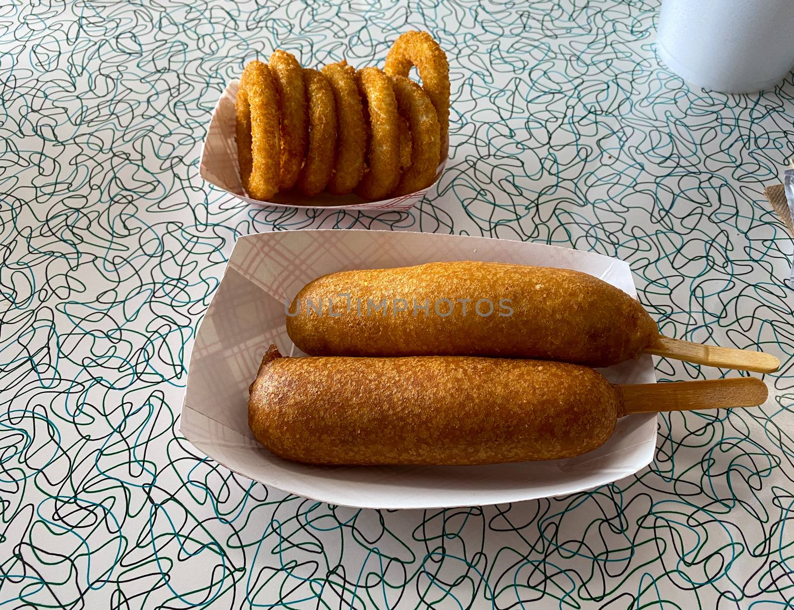 Two corndogs and a side of onion rings meal at a fast food restaurant.