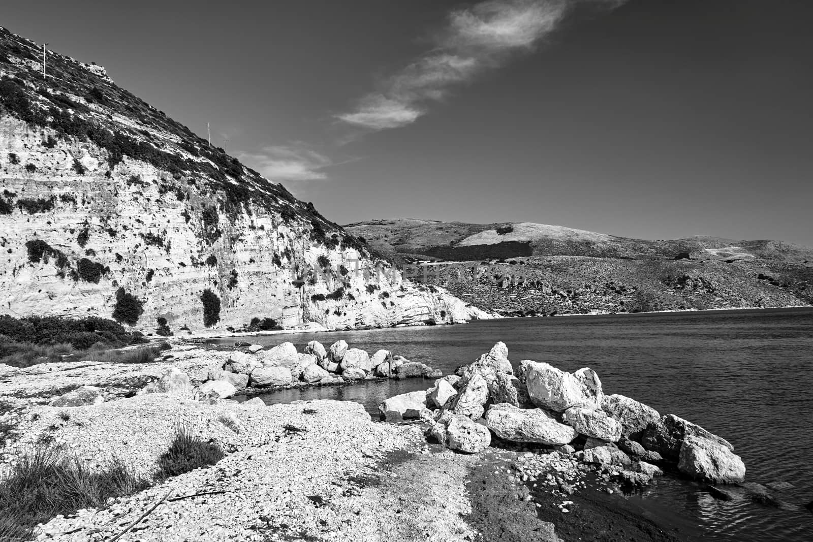 Rocky cliff and boulders in Paliki Bay on the island of Kefalonia in Greece, monochrome