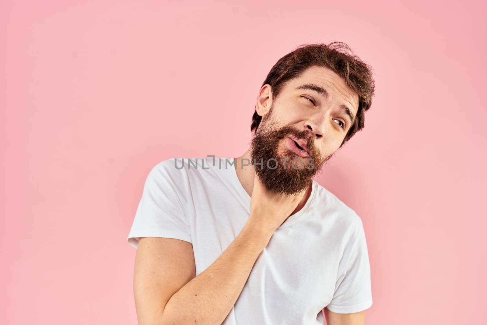 Bearded man white t-shirt cropped view lifestyle studio pink background. High quality photo