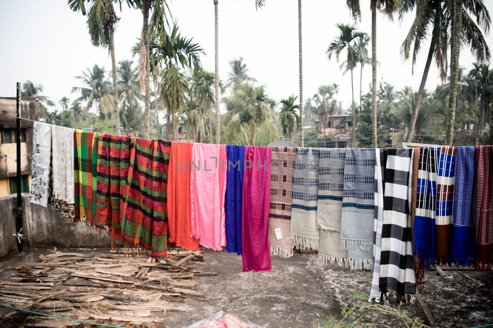 Woolen winter clothes for men and women hang up in Sunlight on a rope hanger on the roof of a residential building for dry the clothes under sun before wearing them. Kolkata India November 5, 2020