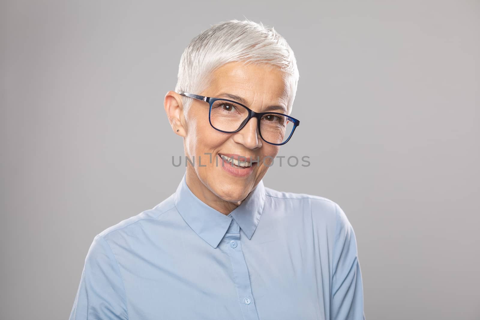 Senior businesswoman with glasses in a blue shirt and short whit by adamr