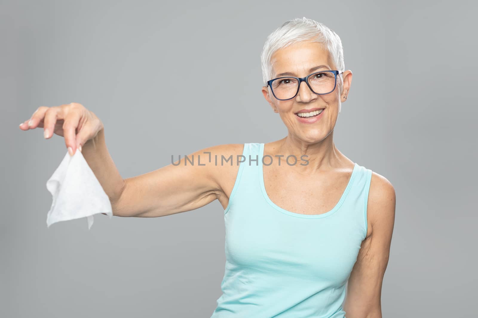 Senior woman cleaning hands and dropping wet wipes - care for health and prevention of infectious diseases stock photo