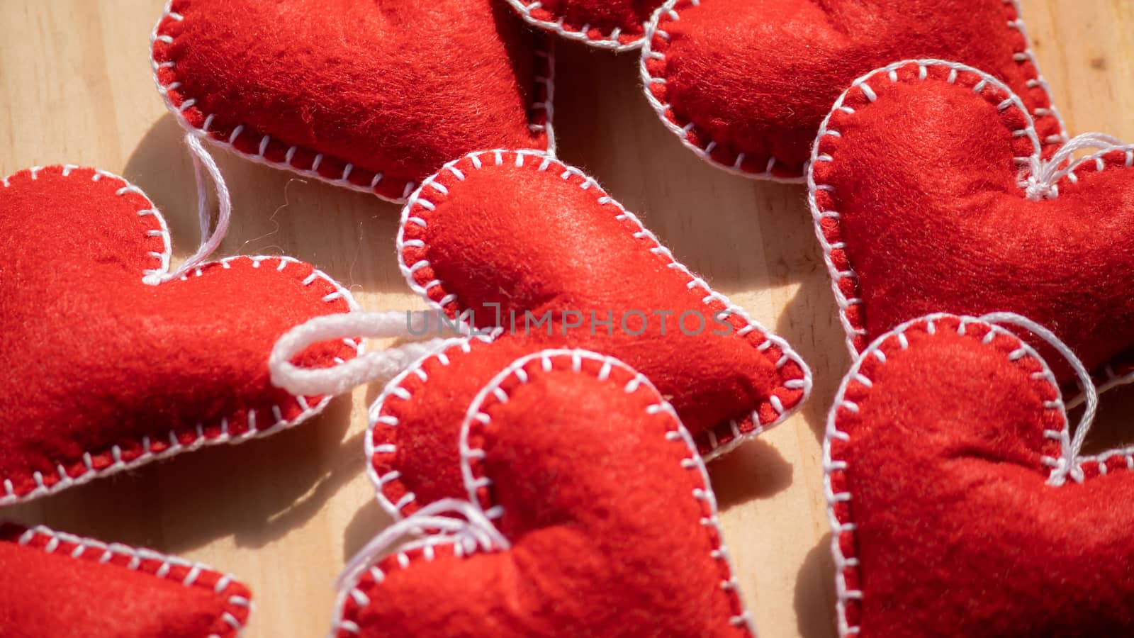 Set of Red felt hearts on a wooden table, romantic handcrafts for Valentine's day close up. by nilanka