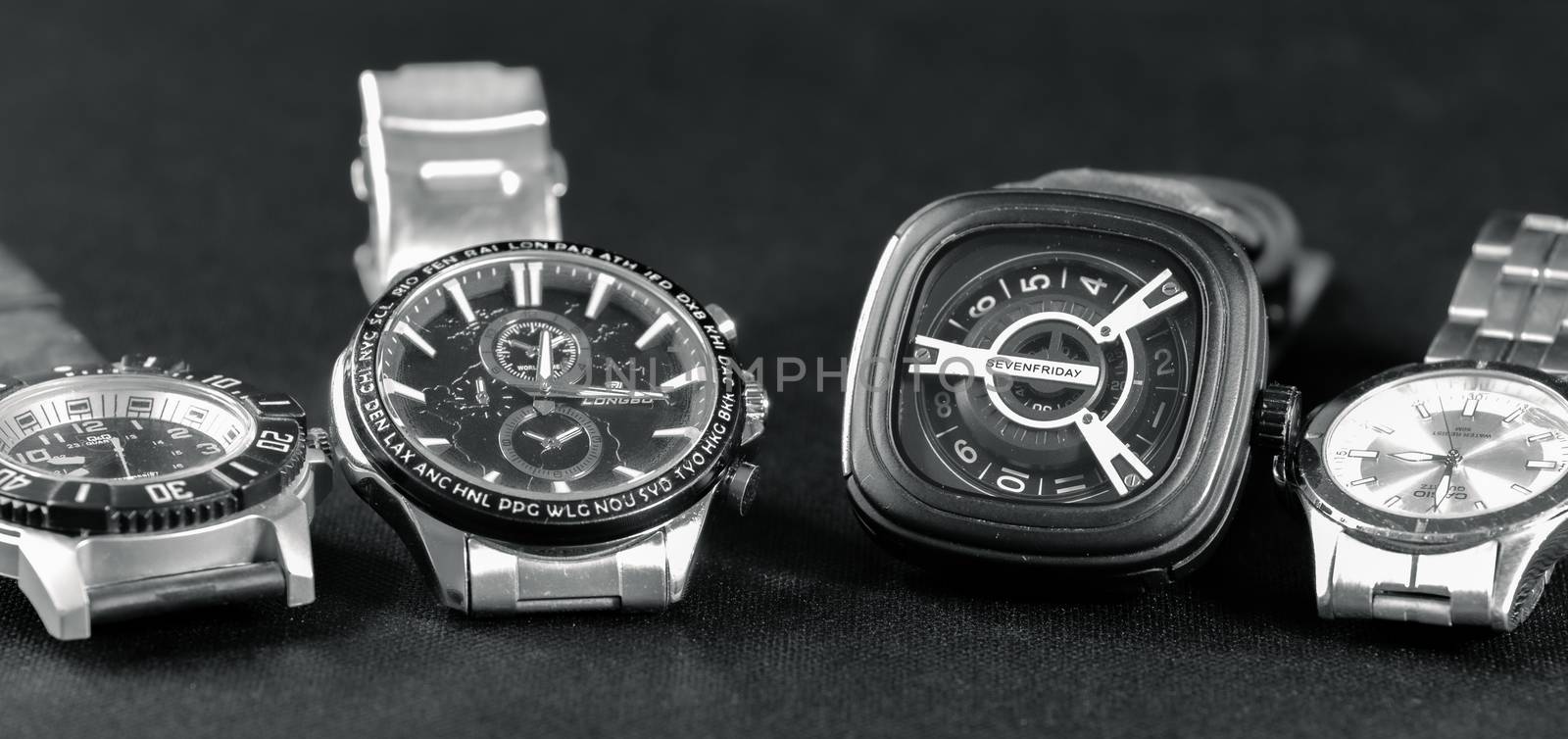 Four watches lined in a dark grey surface.