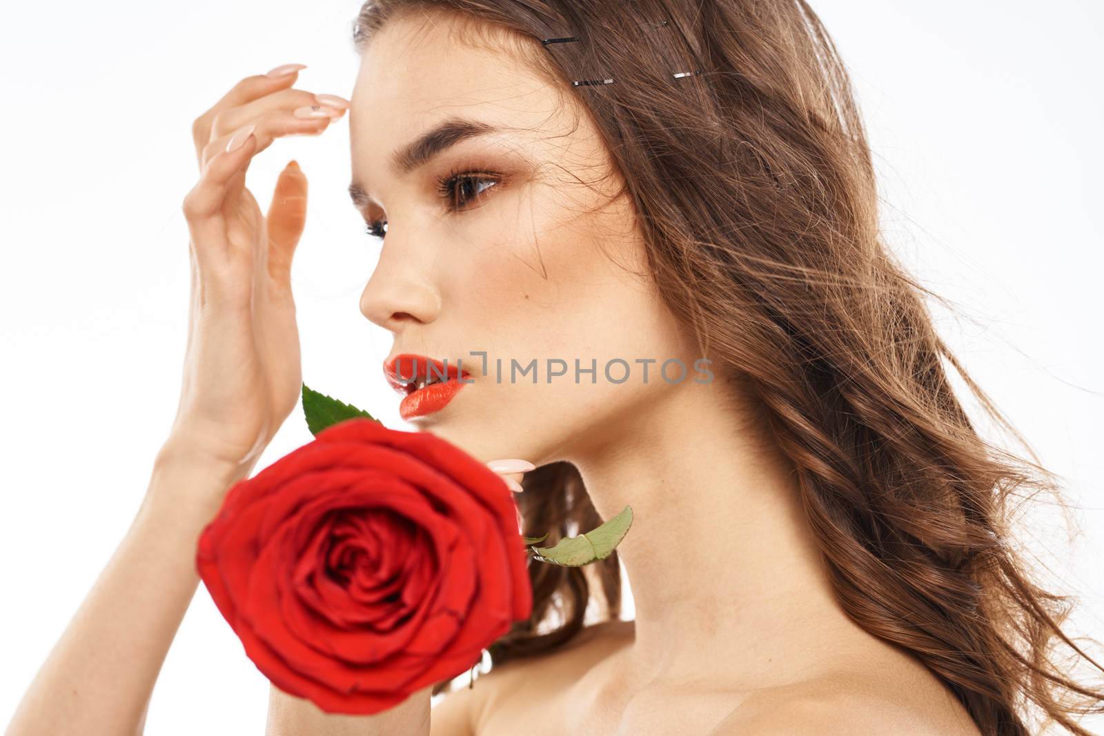 Woman with naked shoulders and red rose evening makeup light background. High quality photo