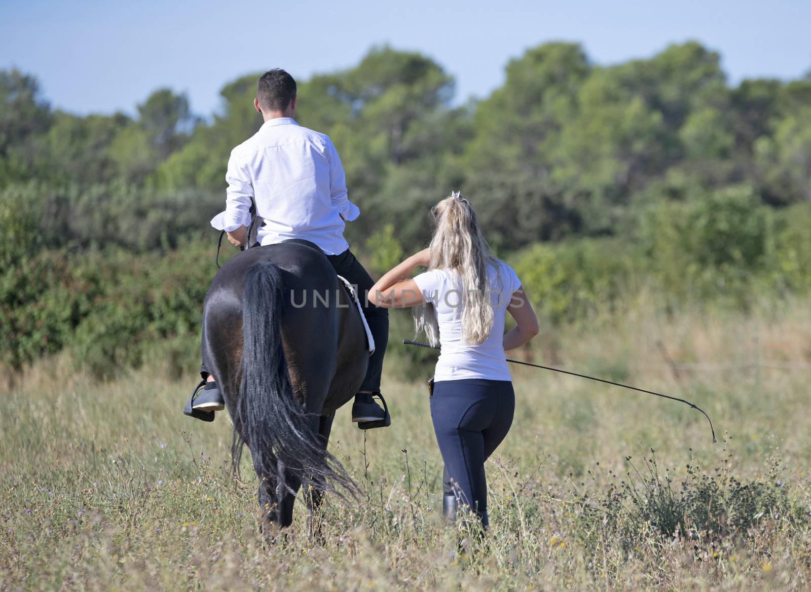  riding teenager are training her black horse